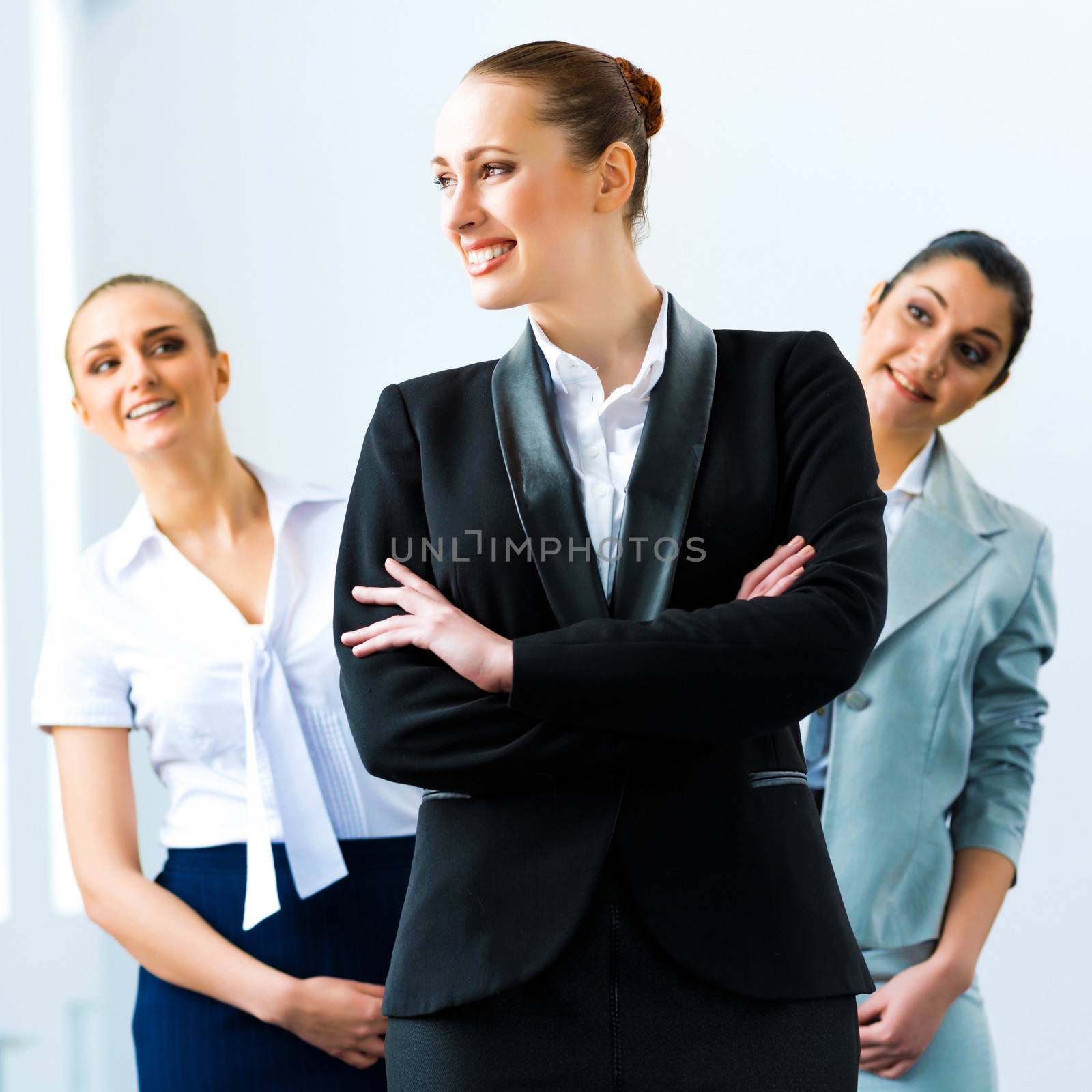 successful business woman in the office, colleagues stare over his shoulder
