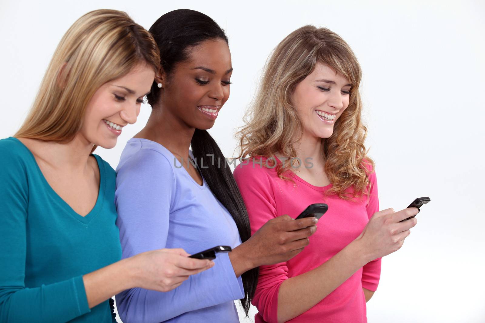 Three female students texting.