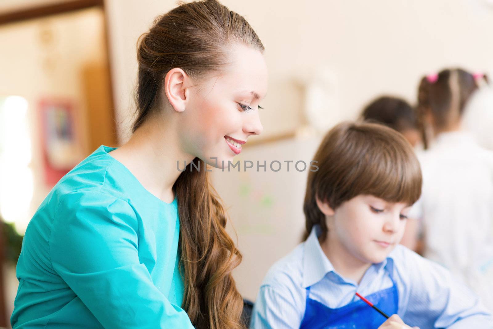 teacher deals with a boy, a drawing lesson