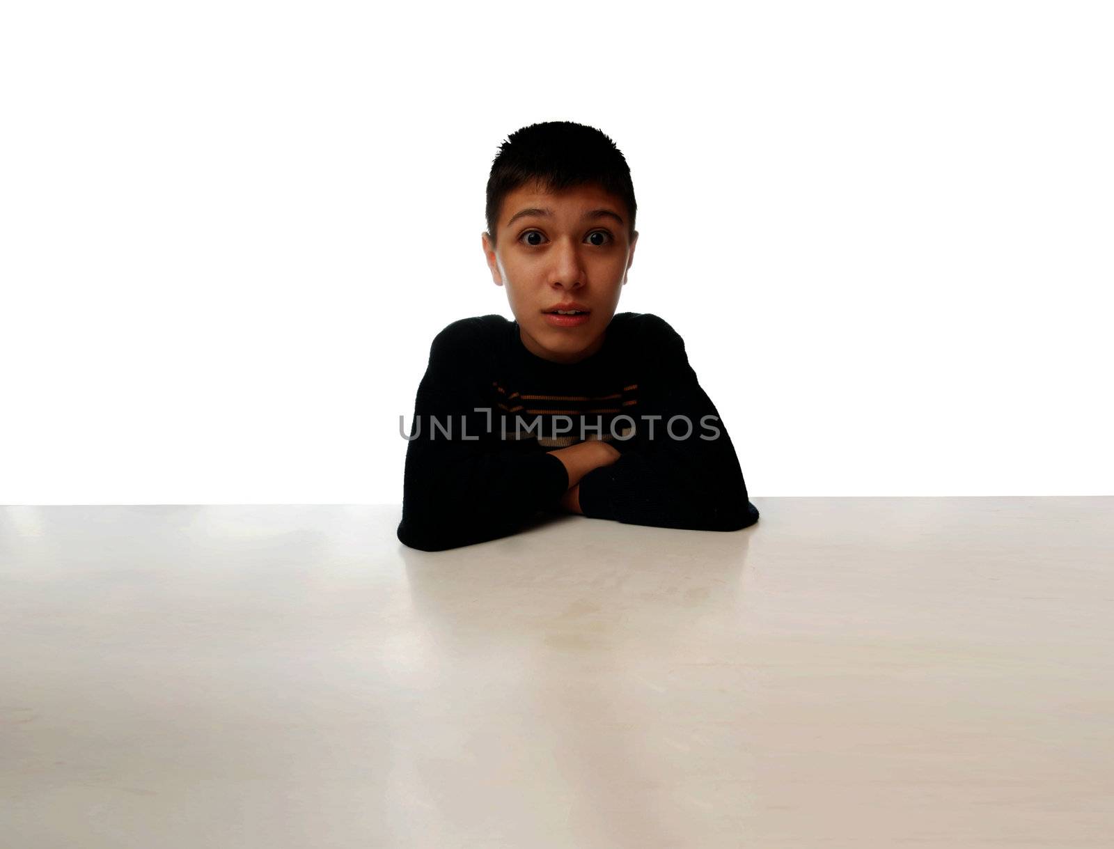 Amazed boy sitting at a huge table as a symbol of human in space