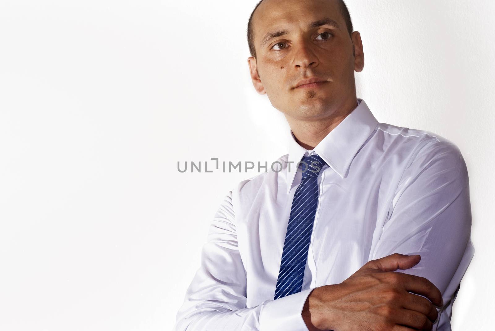 elegant businessman wearing suit looking up at camera isolated on white