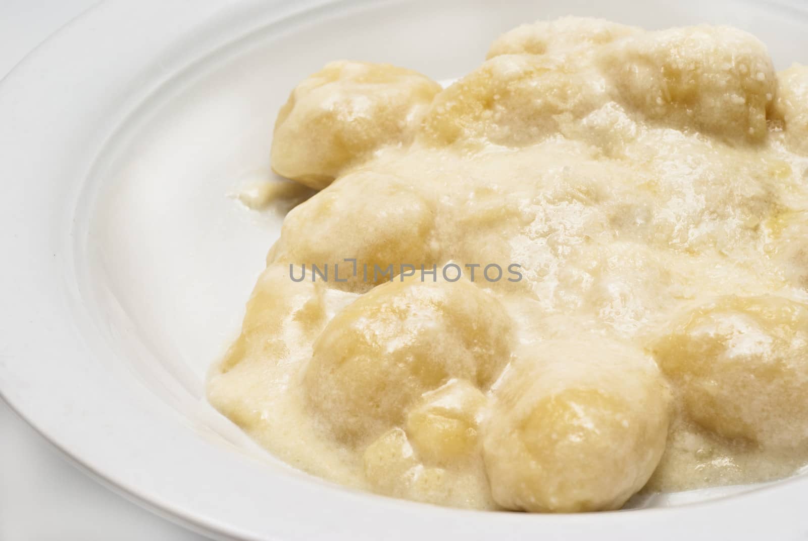 a withe dish of italian gnocchi with four cheese sauce