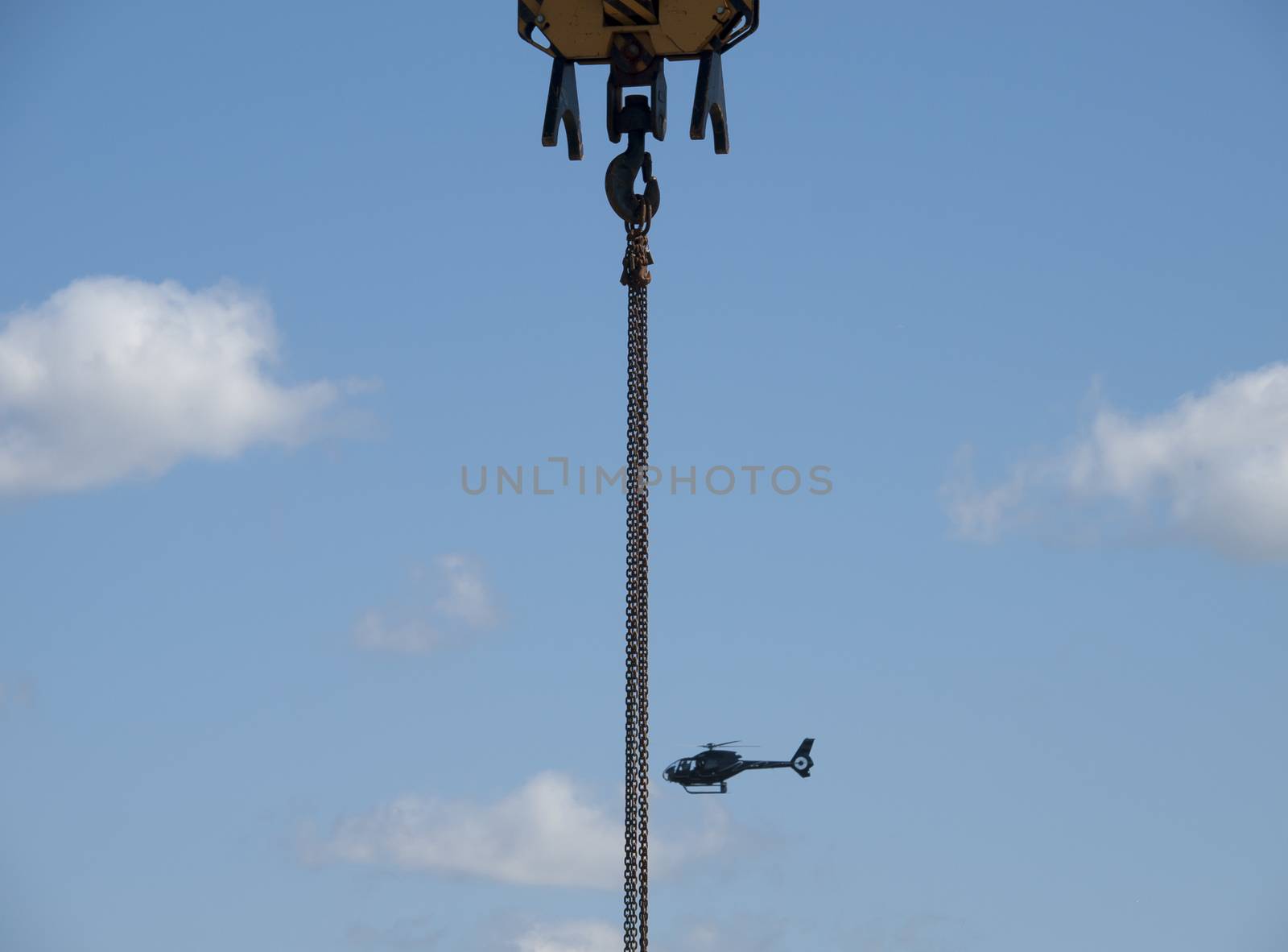 construction crane and a helicopter with a blue sky