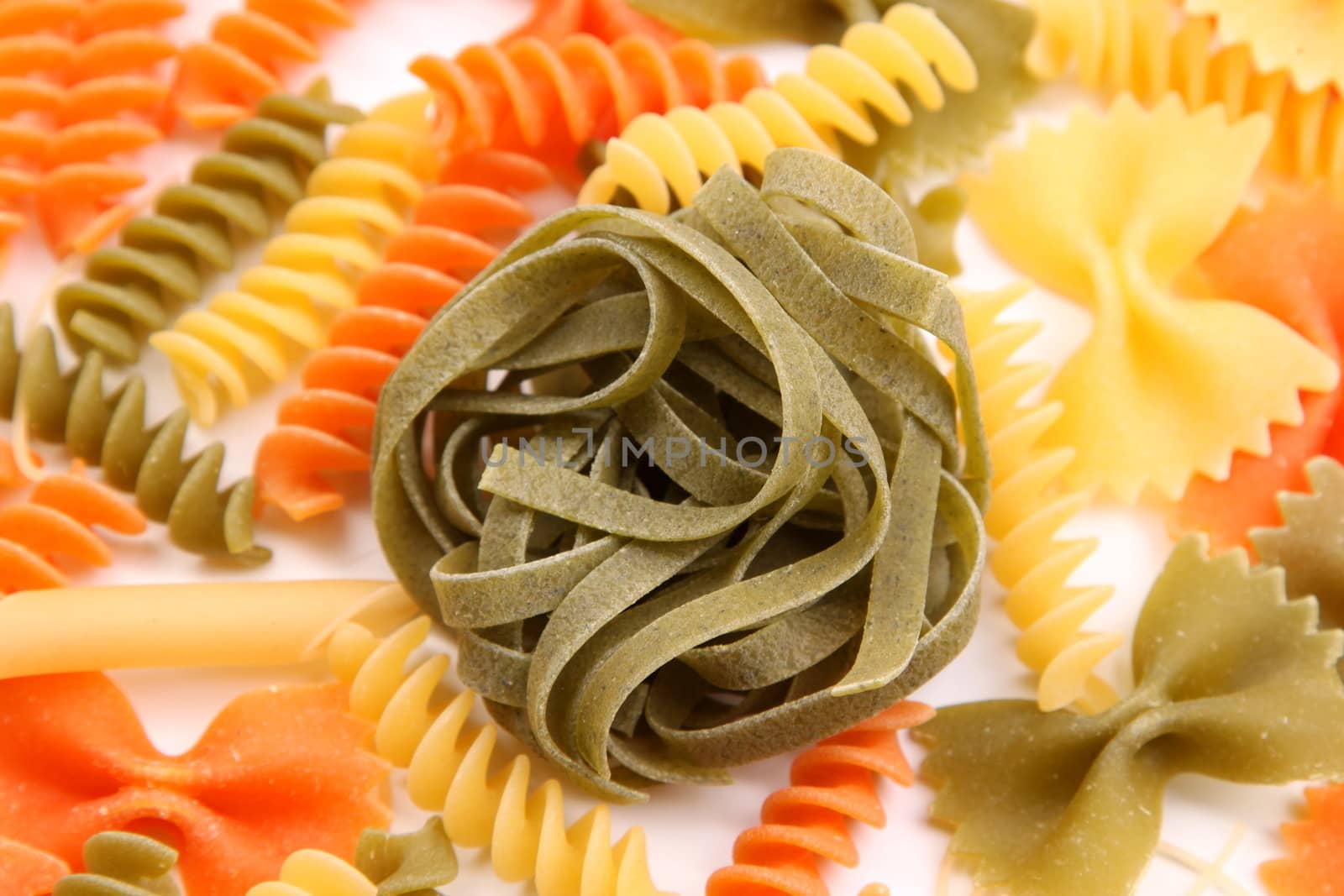 Green tagliatelle paglia e fieno on the backgroun of different pastas. by indigolotos