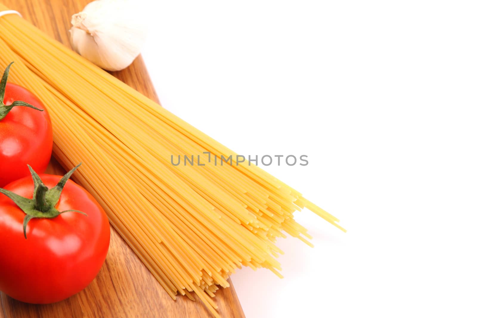 uncooked spaghetti and tomatos are located right on a white background