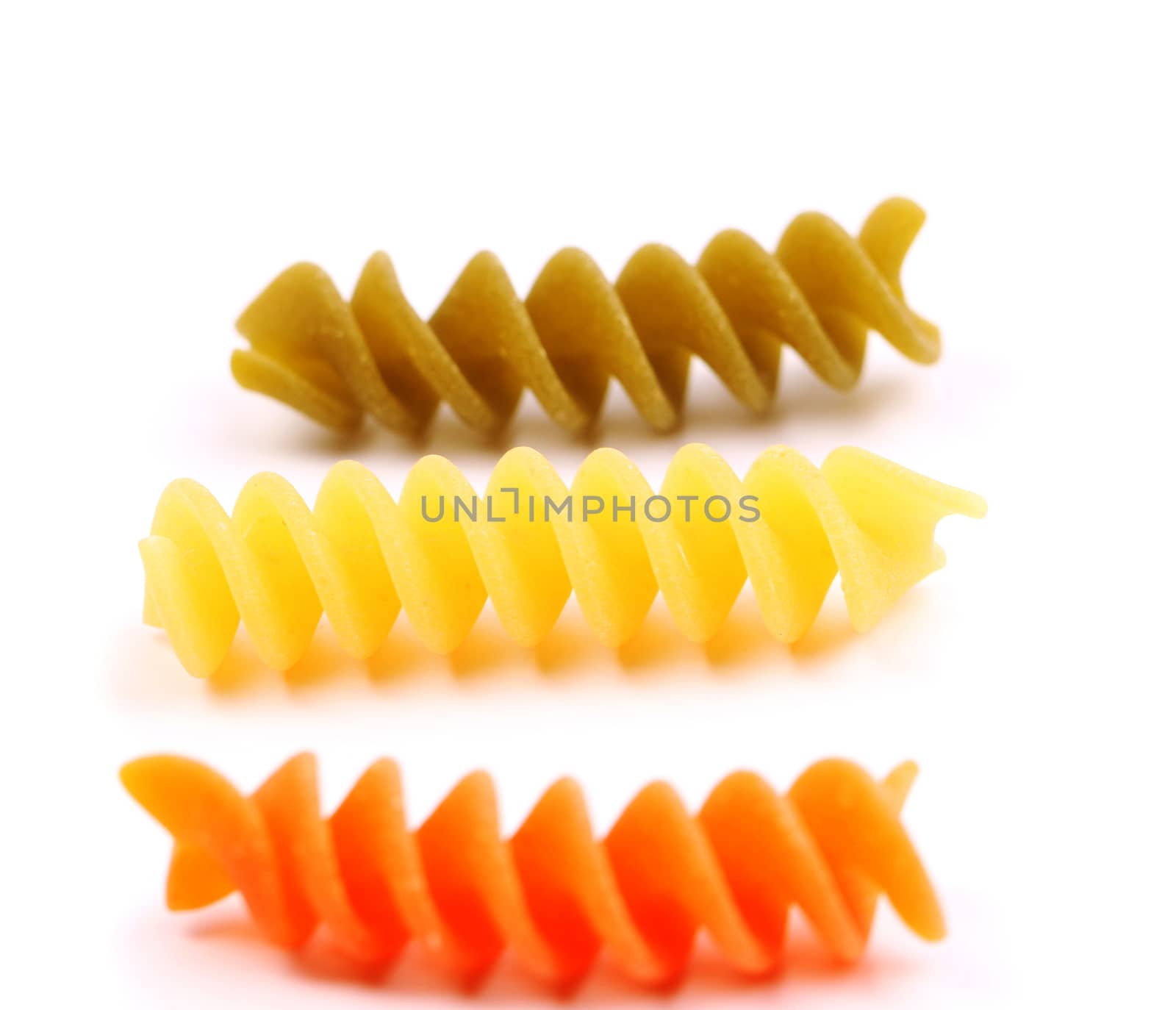 Close-up pasta eliche tricolori are located on the white background.