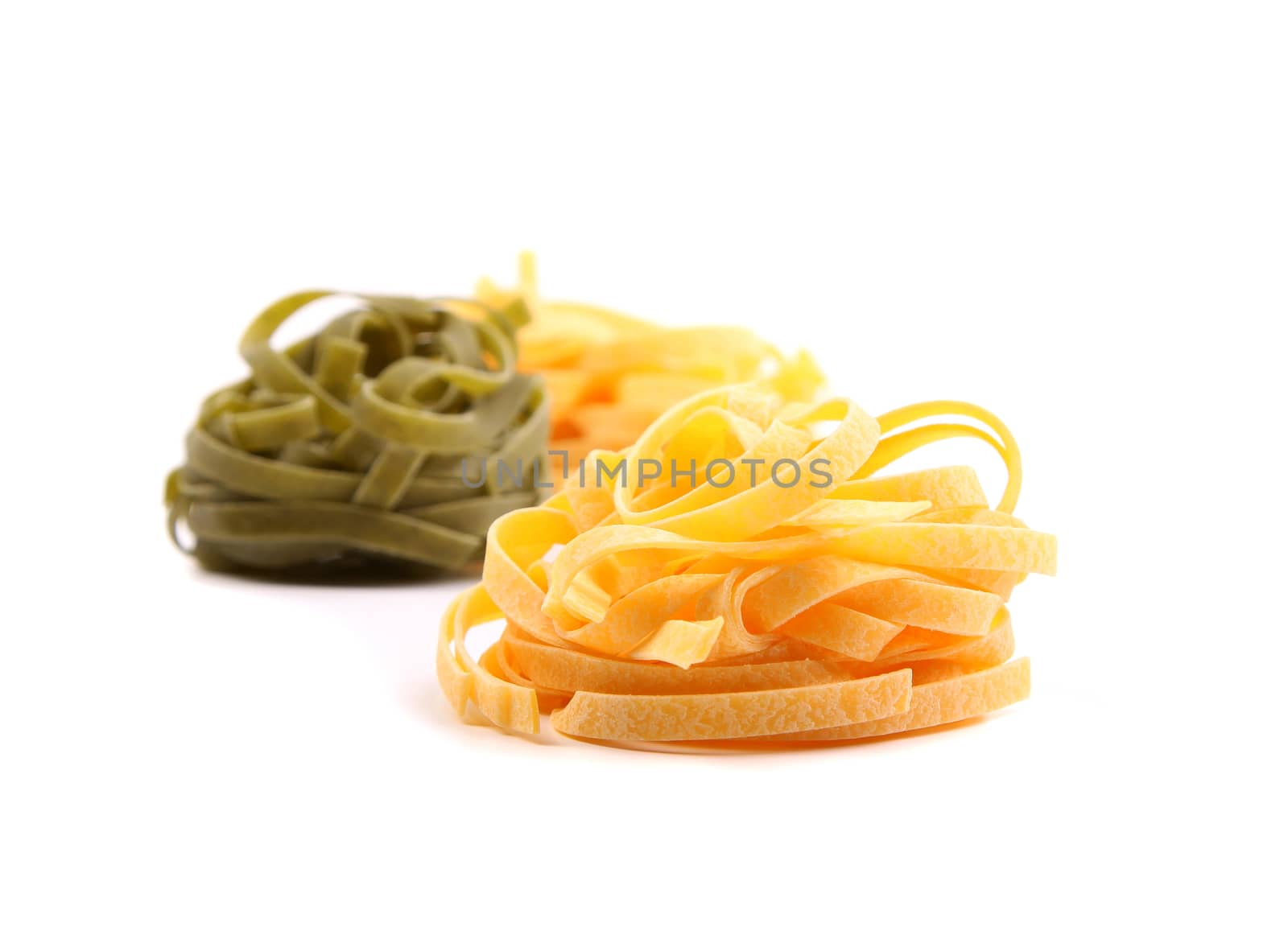 Tagliatelle paglia e fieno homemade tipycal italian pasta close-up on the white background