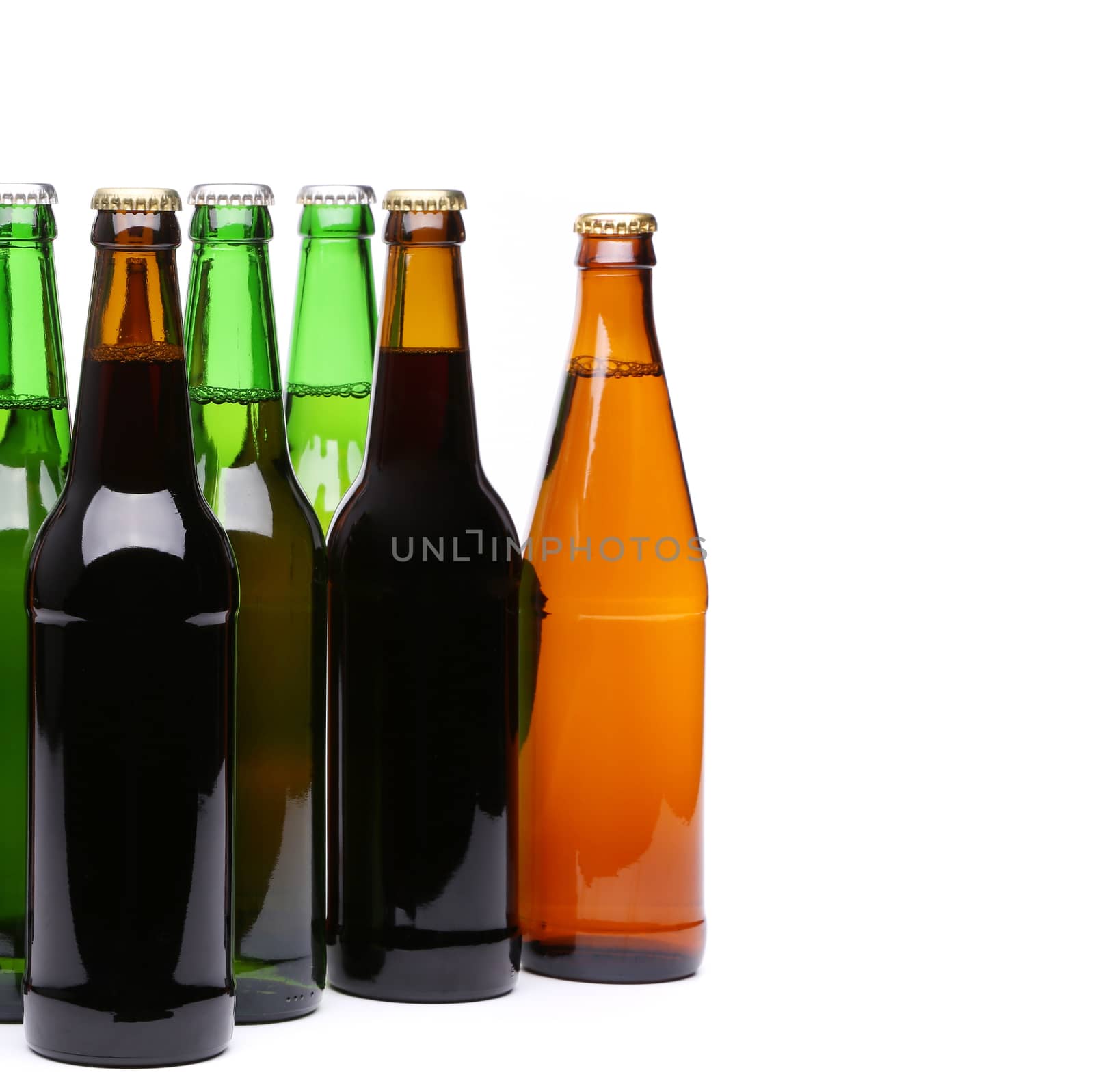 Closed bottles of beer are located left on a white background