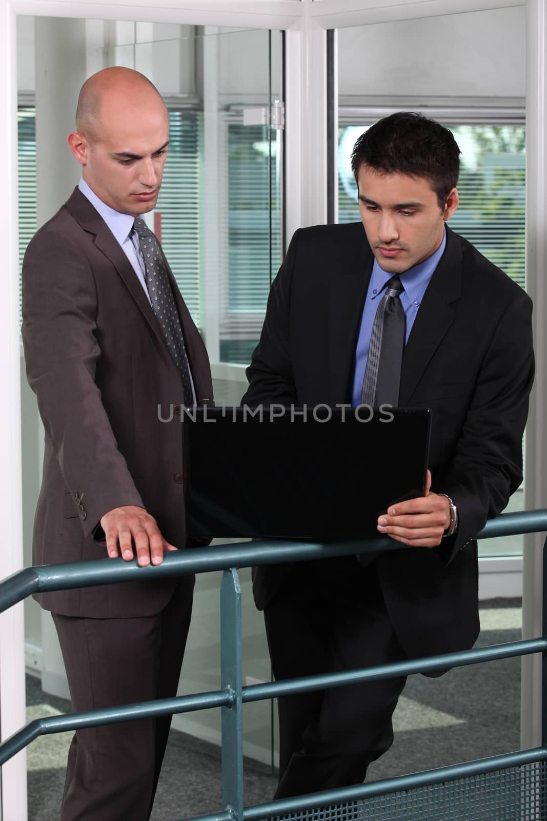 Business colleagues with a laptop by phovoir
