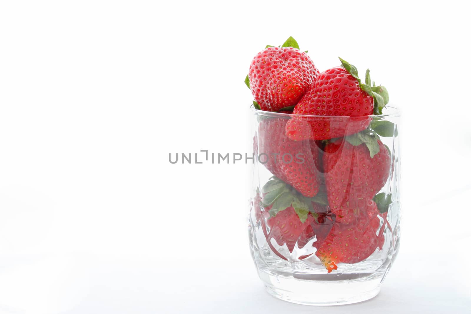 strawberry in glass over white