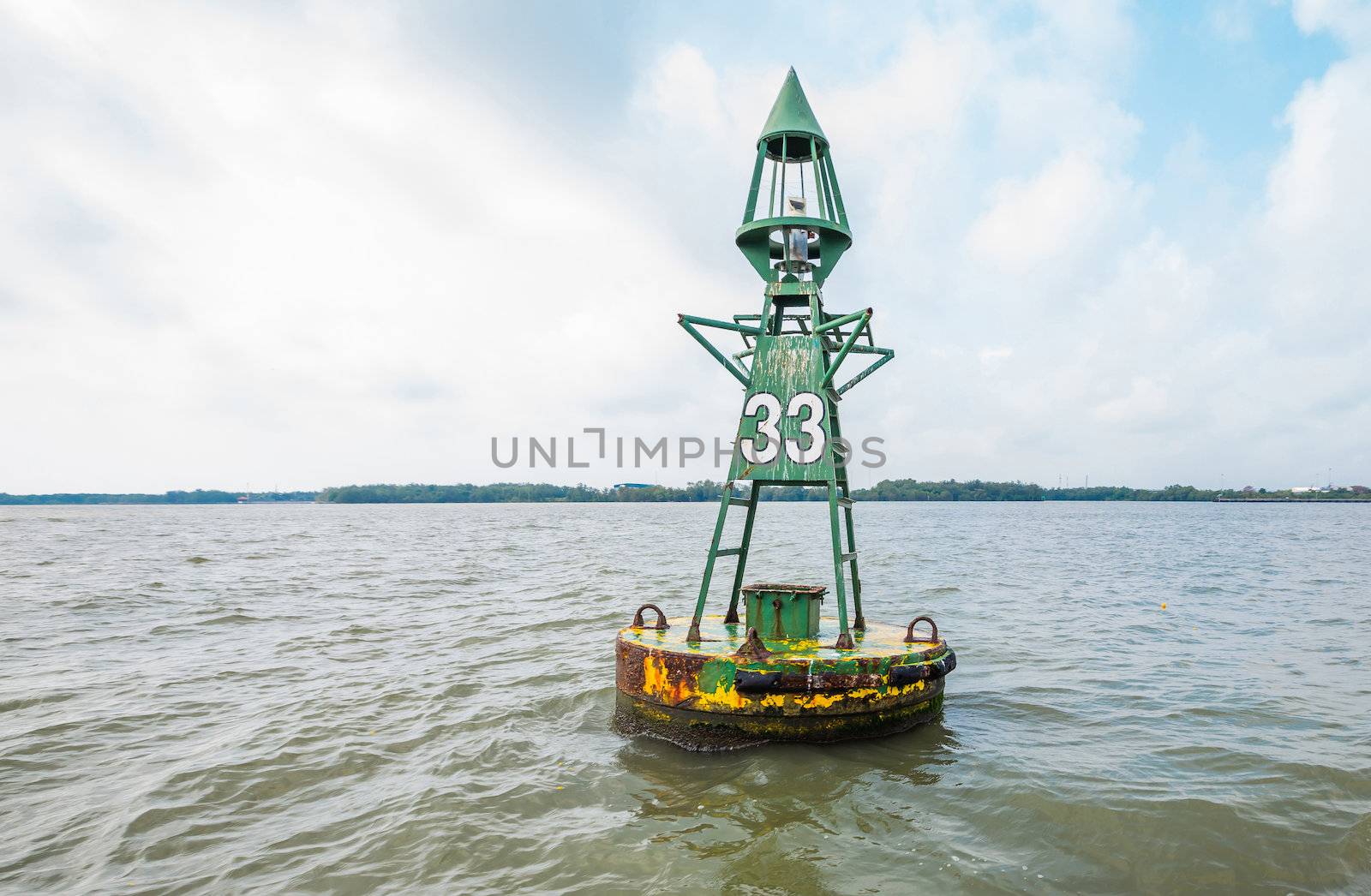 Floating rusty sea buoy - marine boy number 33 in cloudy day