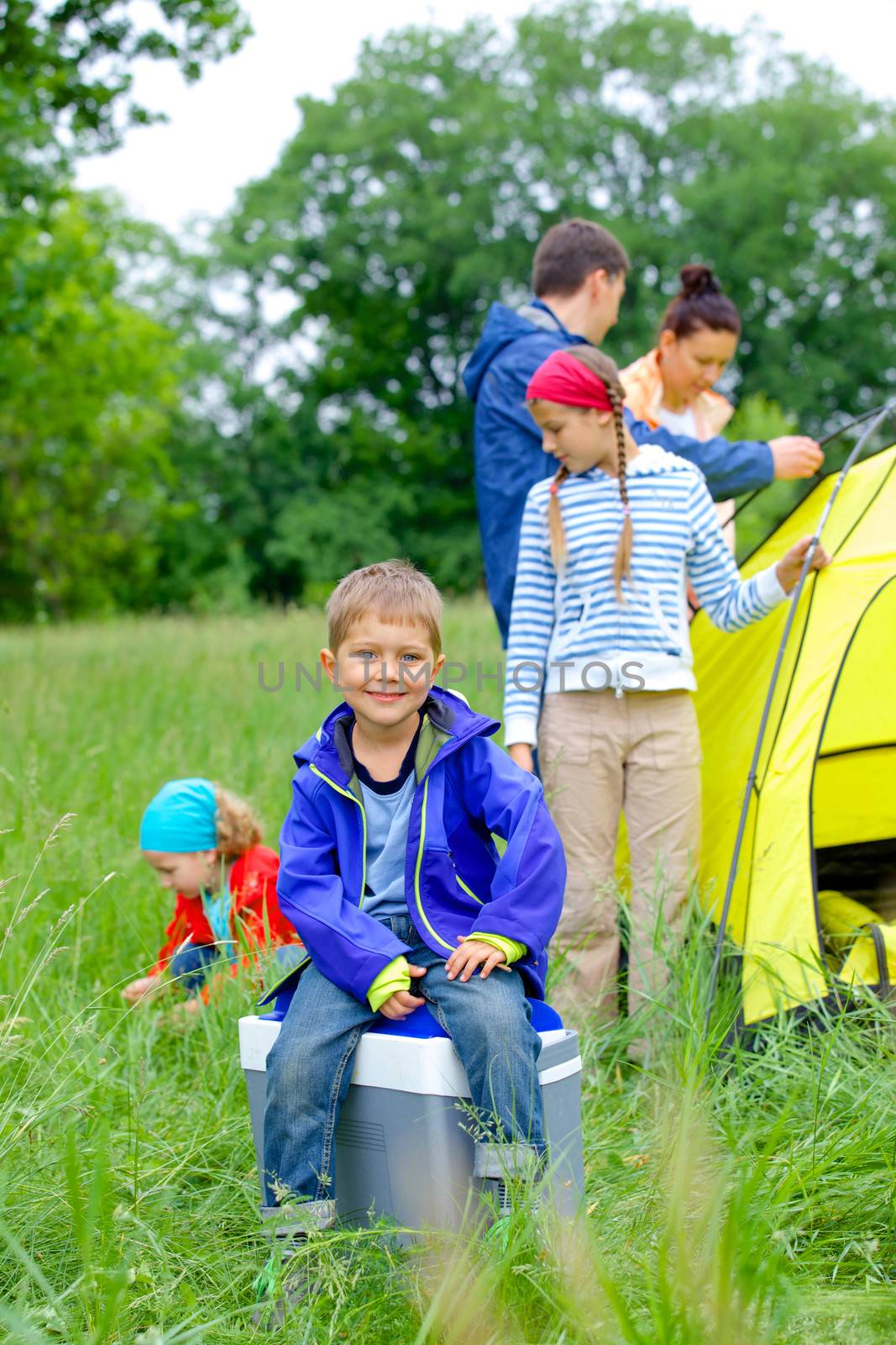 Young boy with his family near tent in camping on the nature