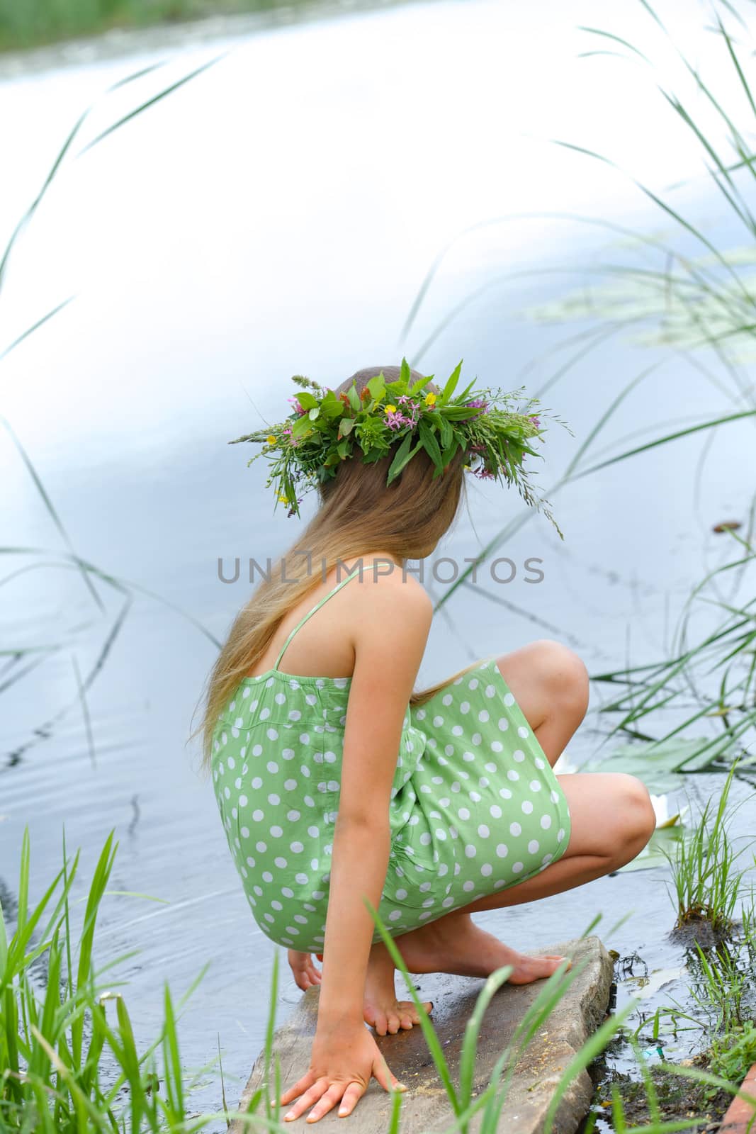 Spring portrait beautiful girl with wreath of flowers. Vertical view