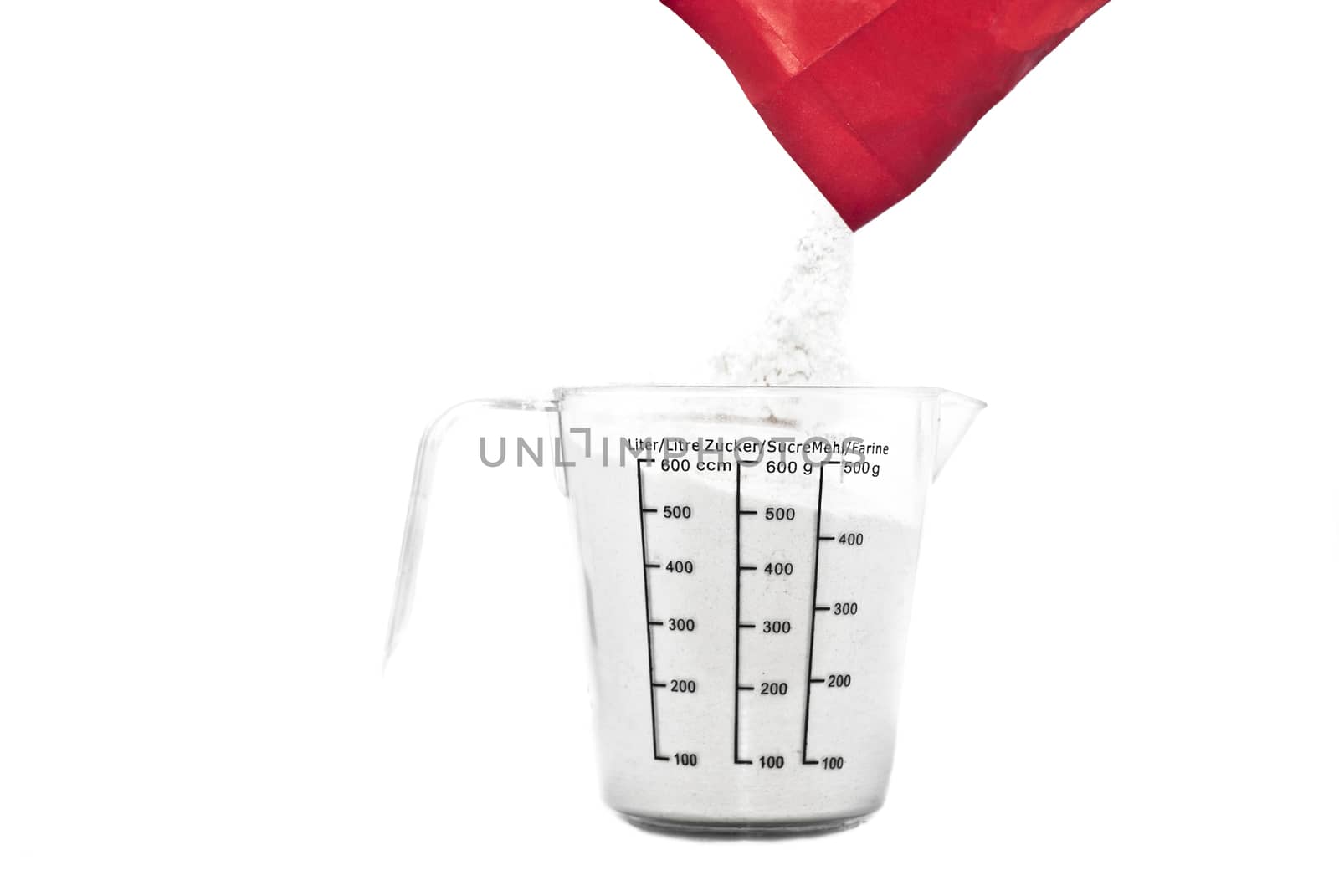  Pouring flour on Kitchen measuring cup. isolated on white