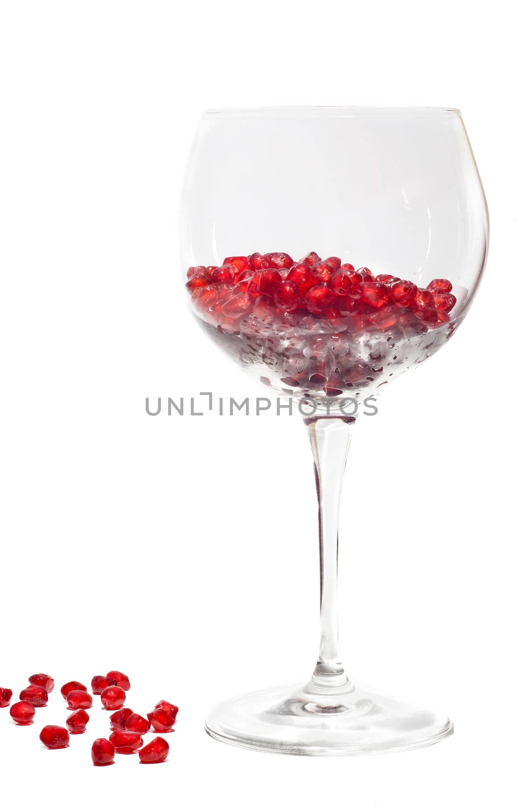 fresh grains of pomegranate in wine glass isolated on white background
