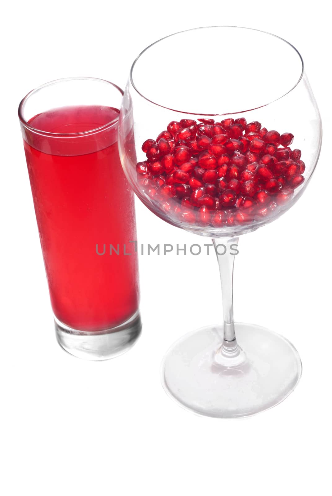 fresh grains and juice pomegranate in glass isolated on white background