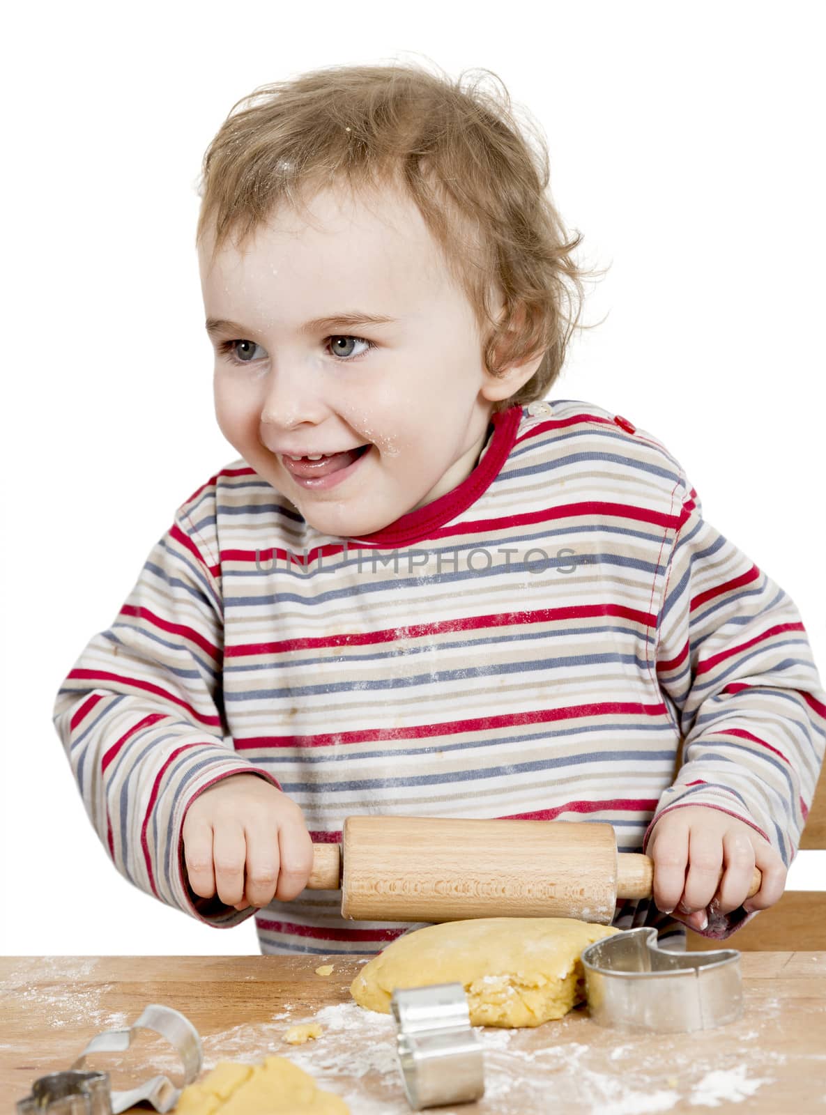 happy young child working with dough in white background by gewoldi