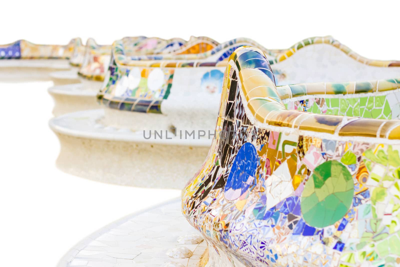 Closeup of colorful ceramic mosaic in a bench of park Guell, isolated on white background. The bench was designed by Antonio Gaudi, in Barcelona, Spain