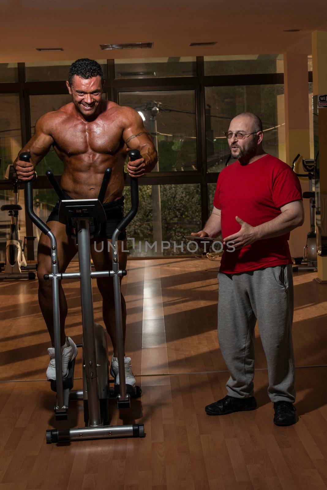 training in gym where partner gives encouragement by JalePhoto