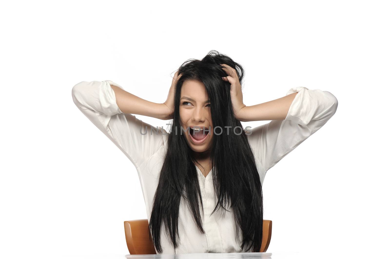 A frustrated and angry woman is screaming out loud and pulling her hair.  by catalineremia