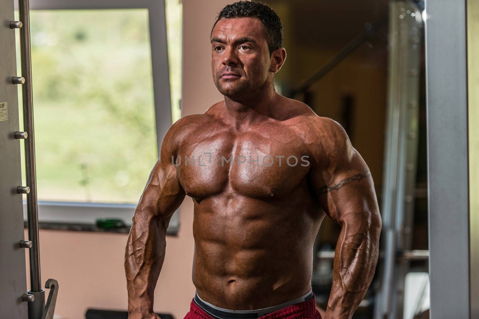 male bodybuilder doing heavy weight exercise for trap by JalePhoto