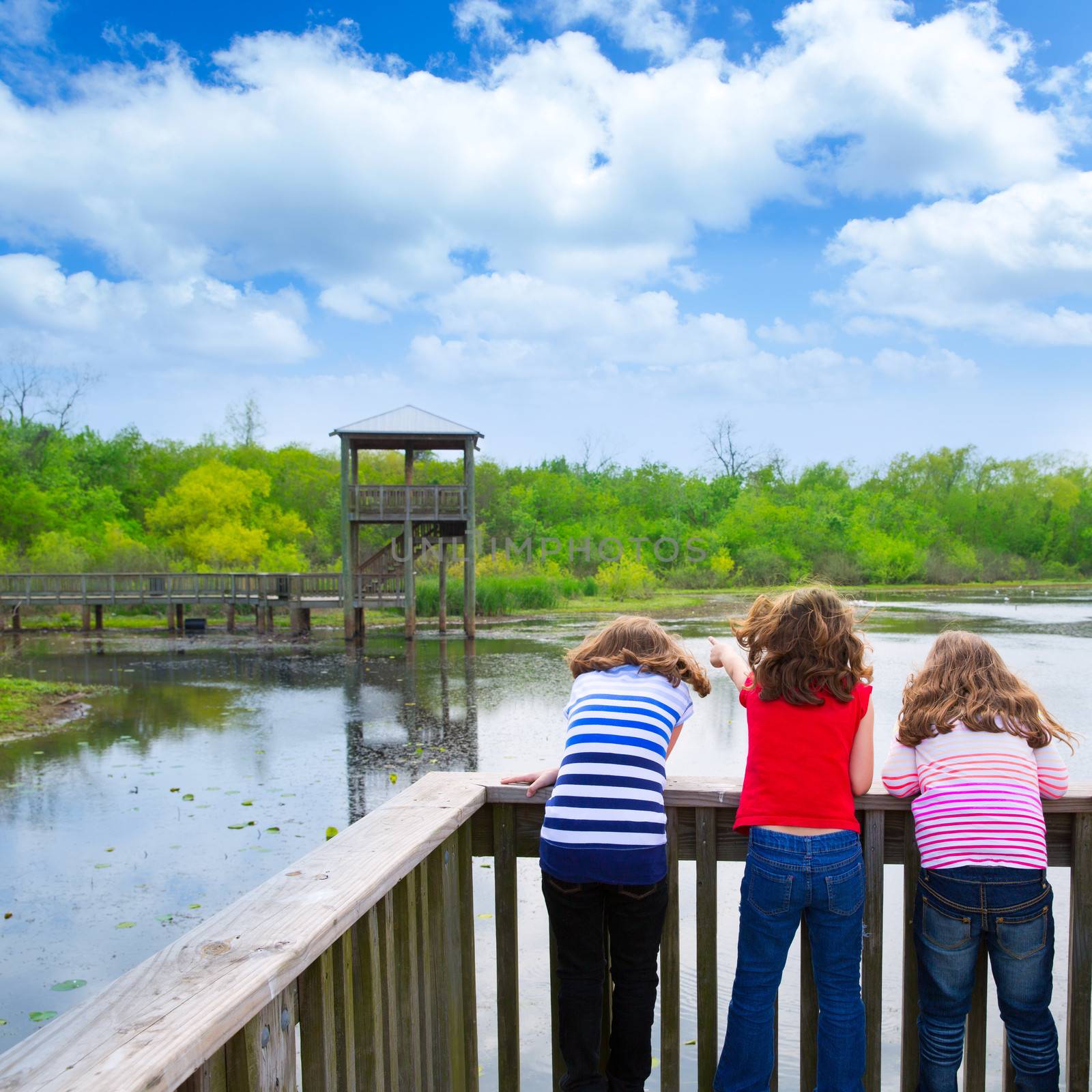 kid children girls looking and pointing at park lake in Texas rear view