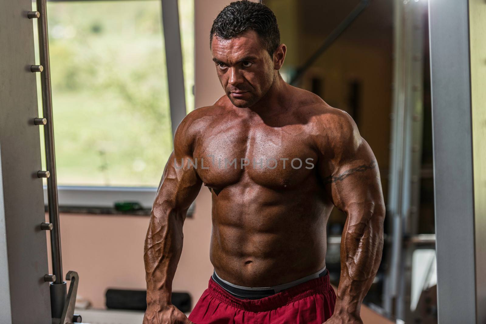 male bodybuilder doing heavy weight exercise for trap by JalePhoto