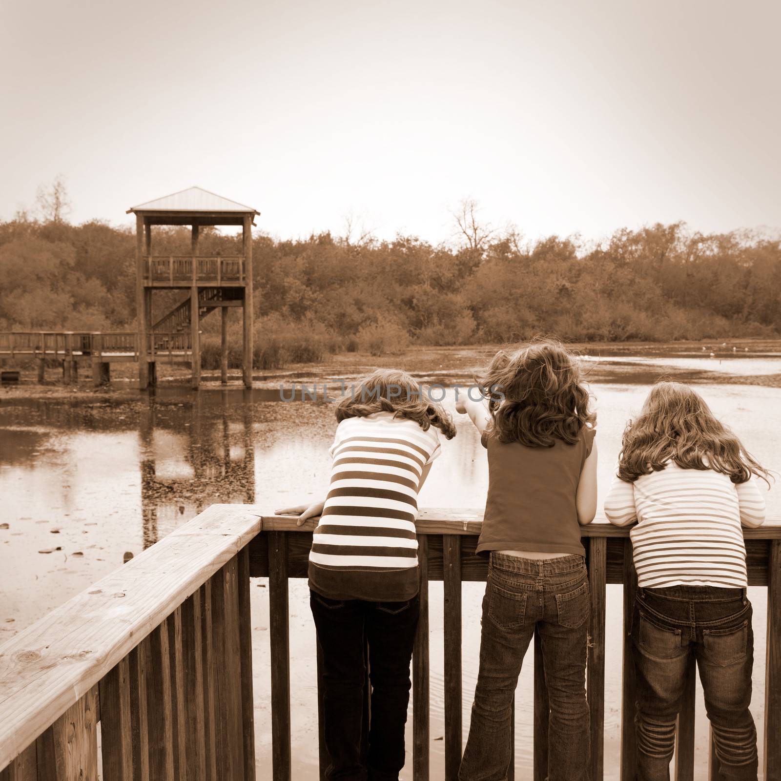 girls looking at park lake in Texas by lunamarina