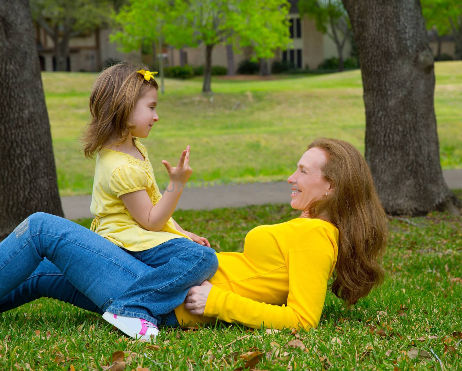 Daughter and mother playing counting lying on lawn by lunamarina