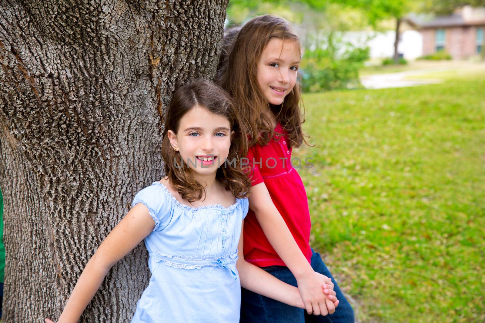 Children group friend girls friends playing on tree trunk at the park outdoor