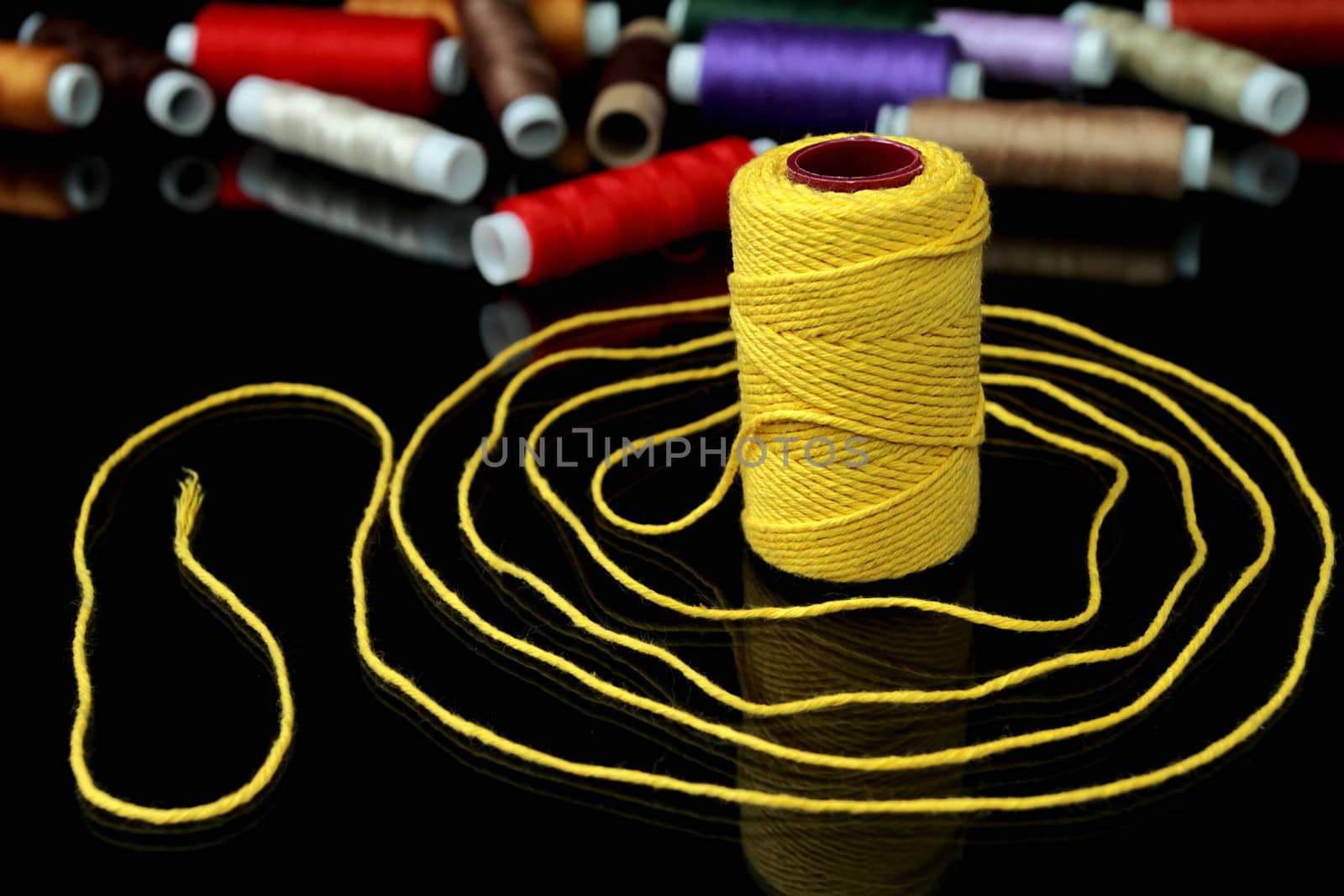 Focus on one reel of thread on a black background