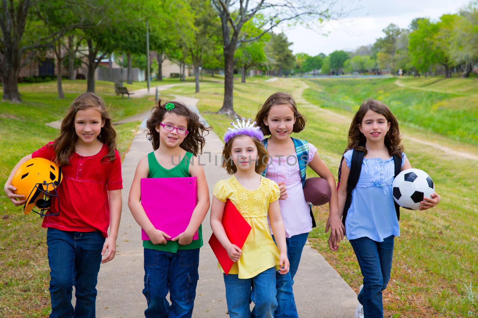 Children kid girls walking to schoool with sport balls folders and backpacks in outdoor park