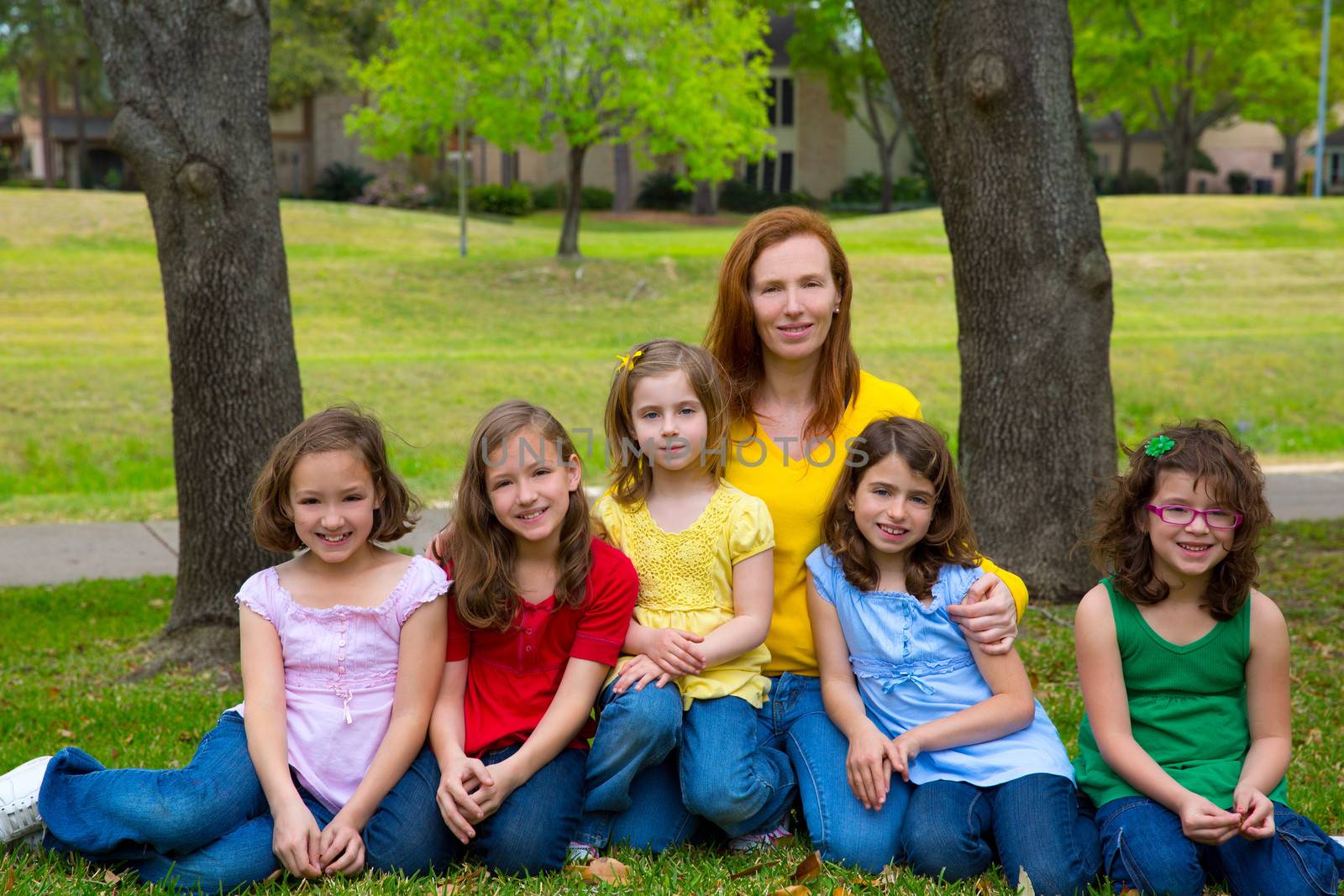 Mother teacher with daughter pupils in playground park by lunamarina