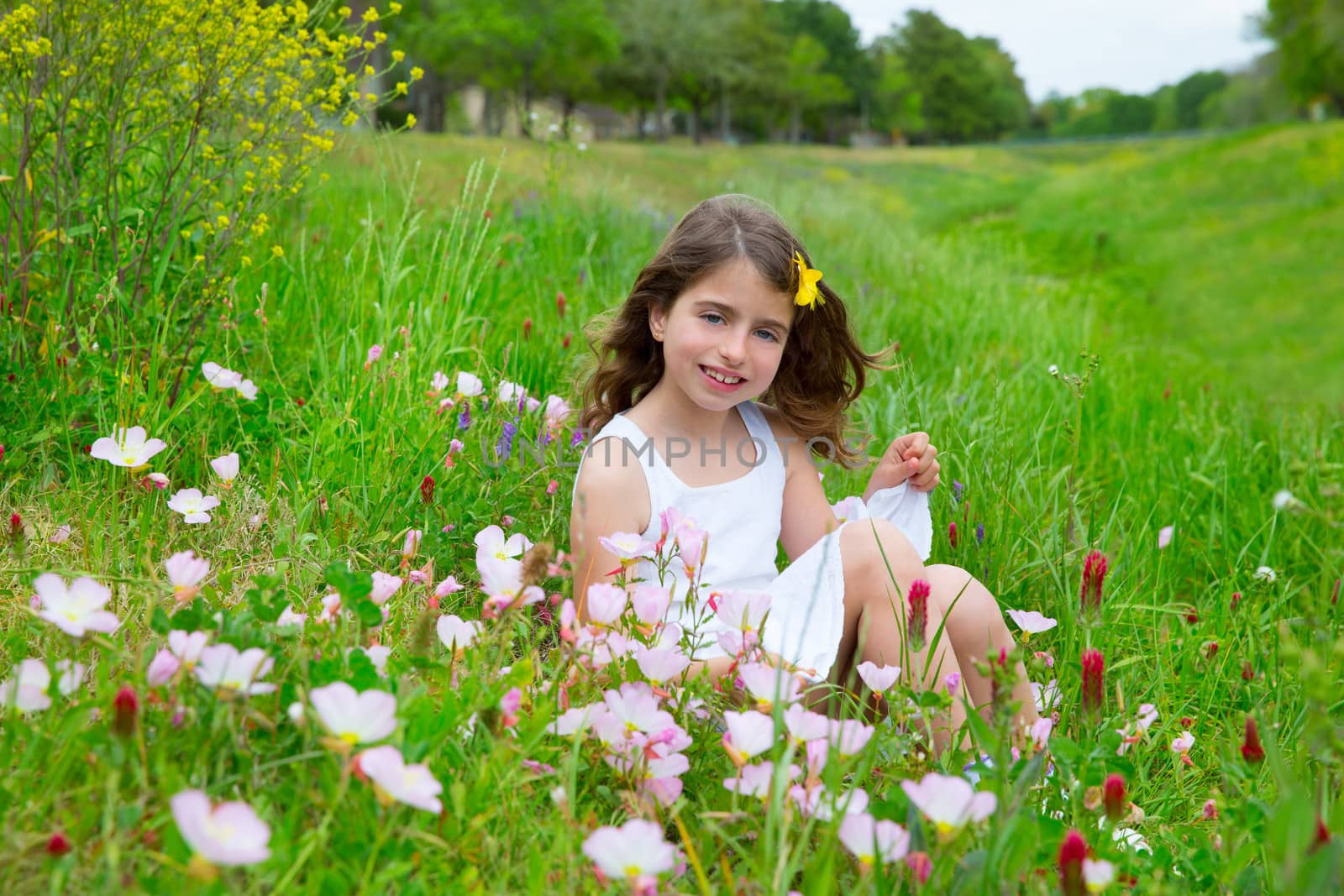 beautiful children girl on spring meadow with poppy flowers