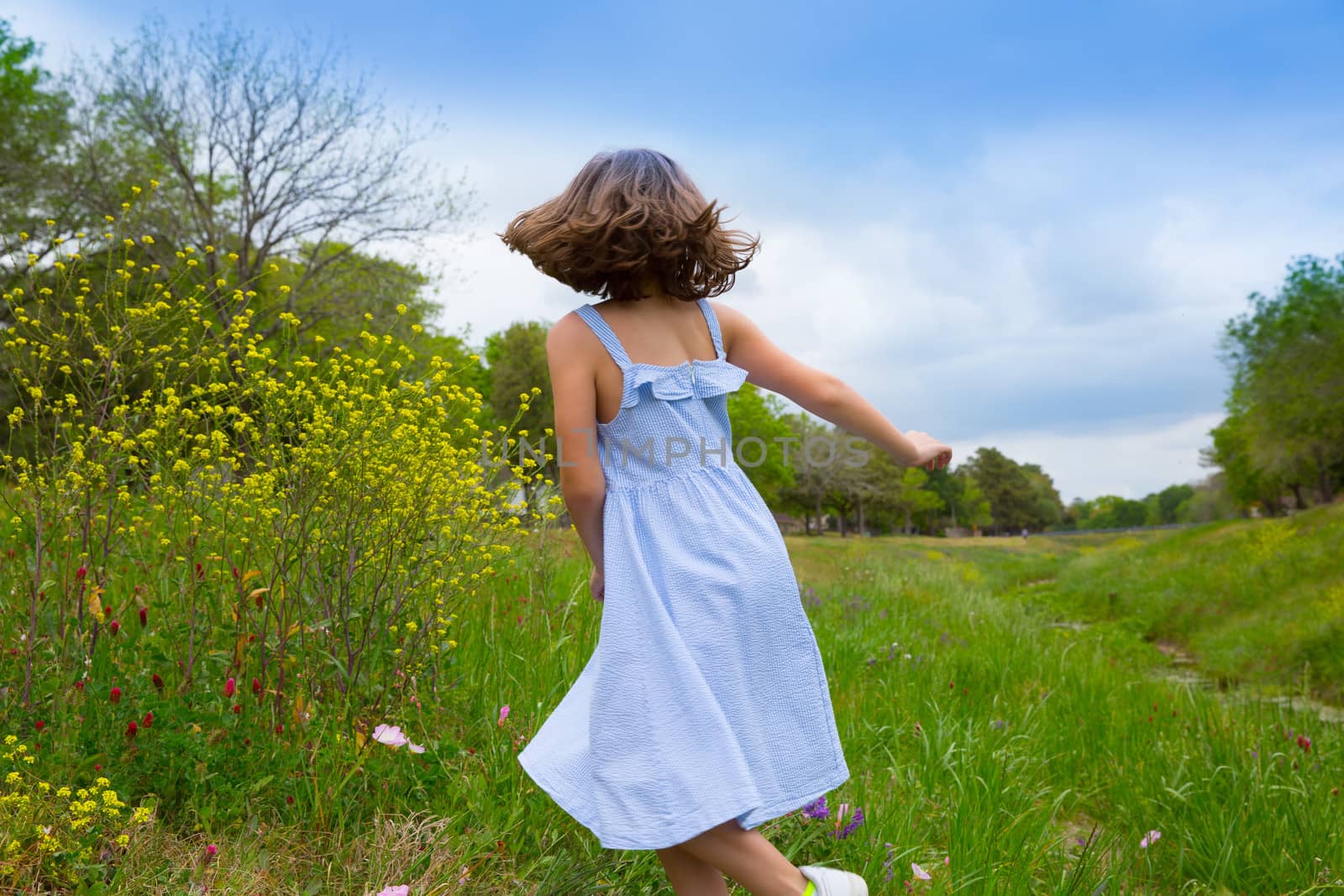 happy children girl jumping on spring poppy flowers meadow with motion blur