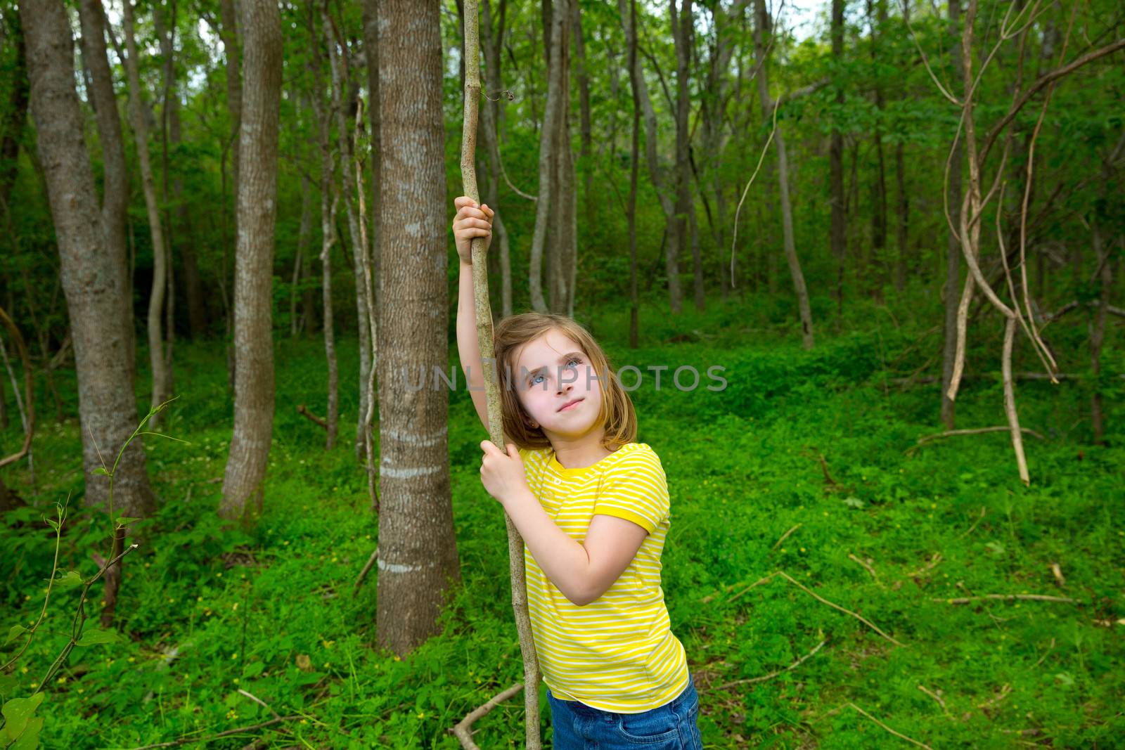 Happy girl playing in forest park jungle with liana by lunamarina