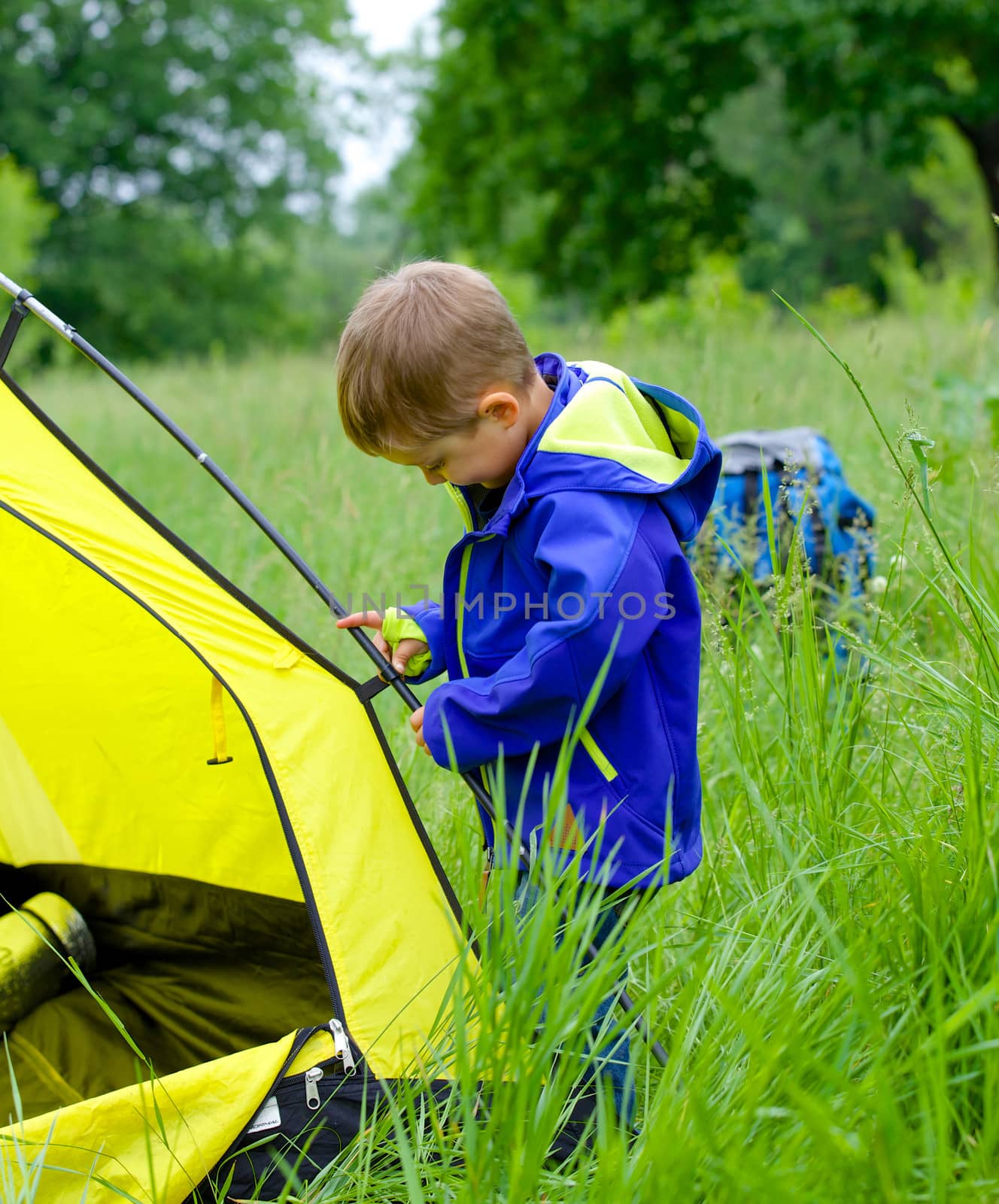 Cute little boy camping with tent outdoor.