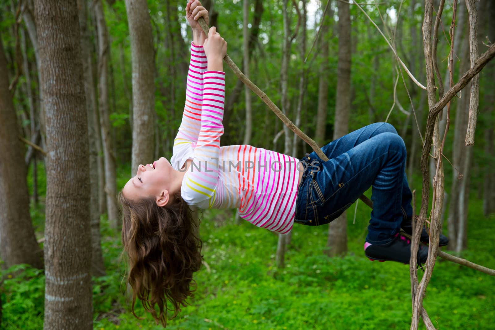 girls playing hanging in lianas at the jungle park by lunamarina