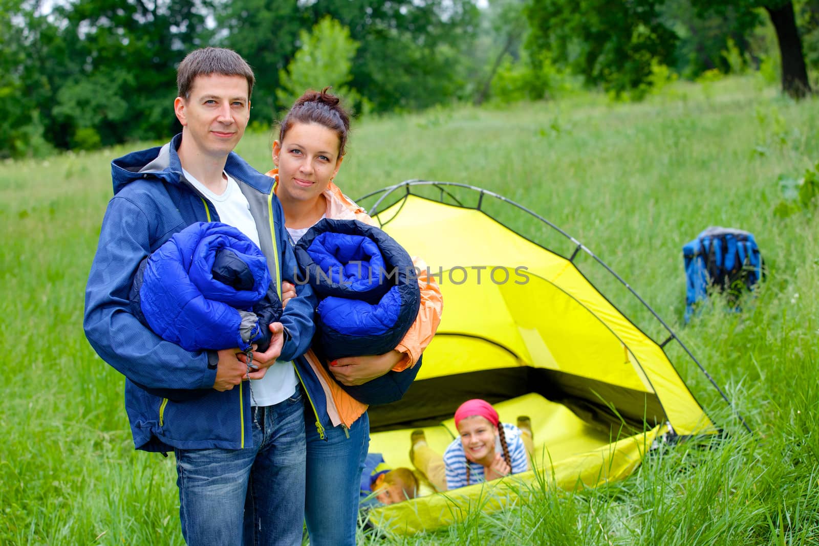 Young happy couple camping near tent in park