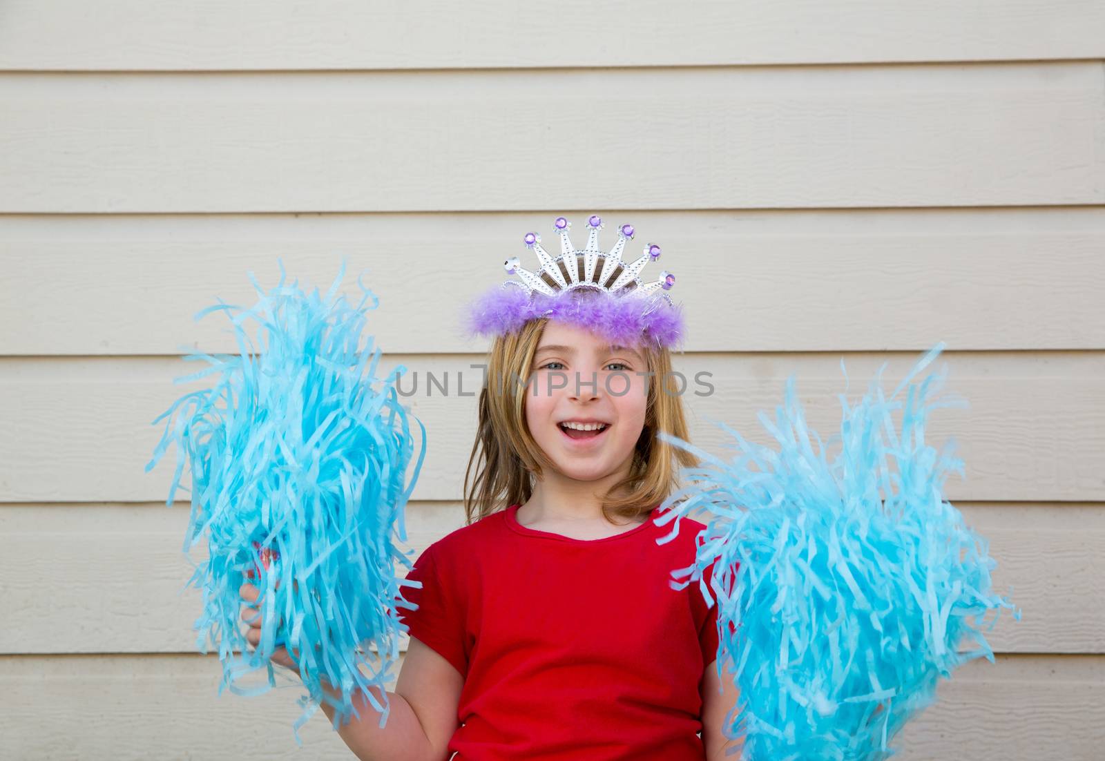 Blond kid girl playing like cheerleading pom poms with princess crown