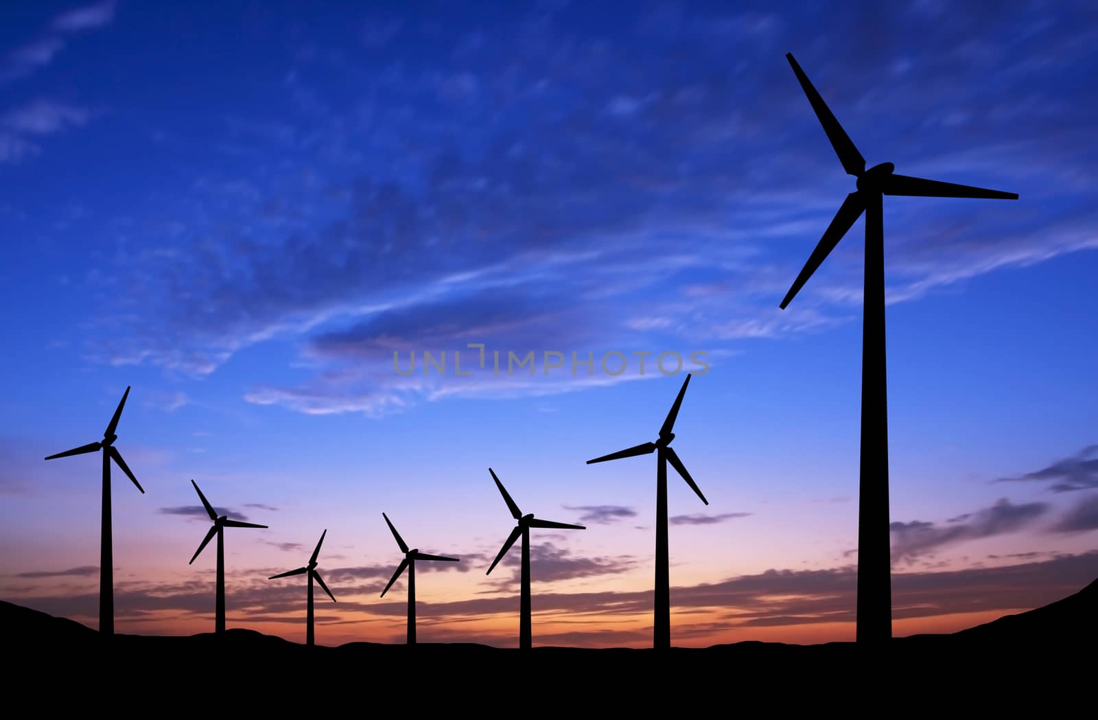 Silhouette of windmills on sunset background with space