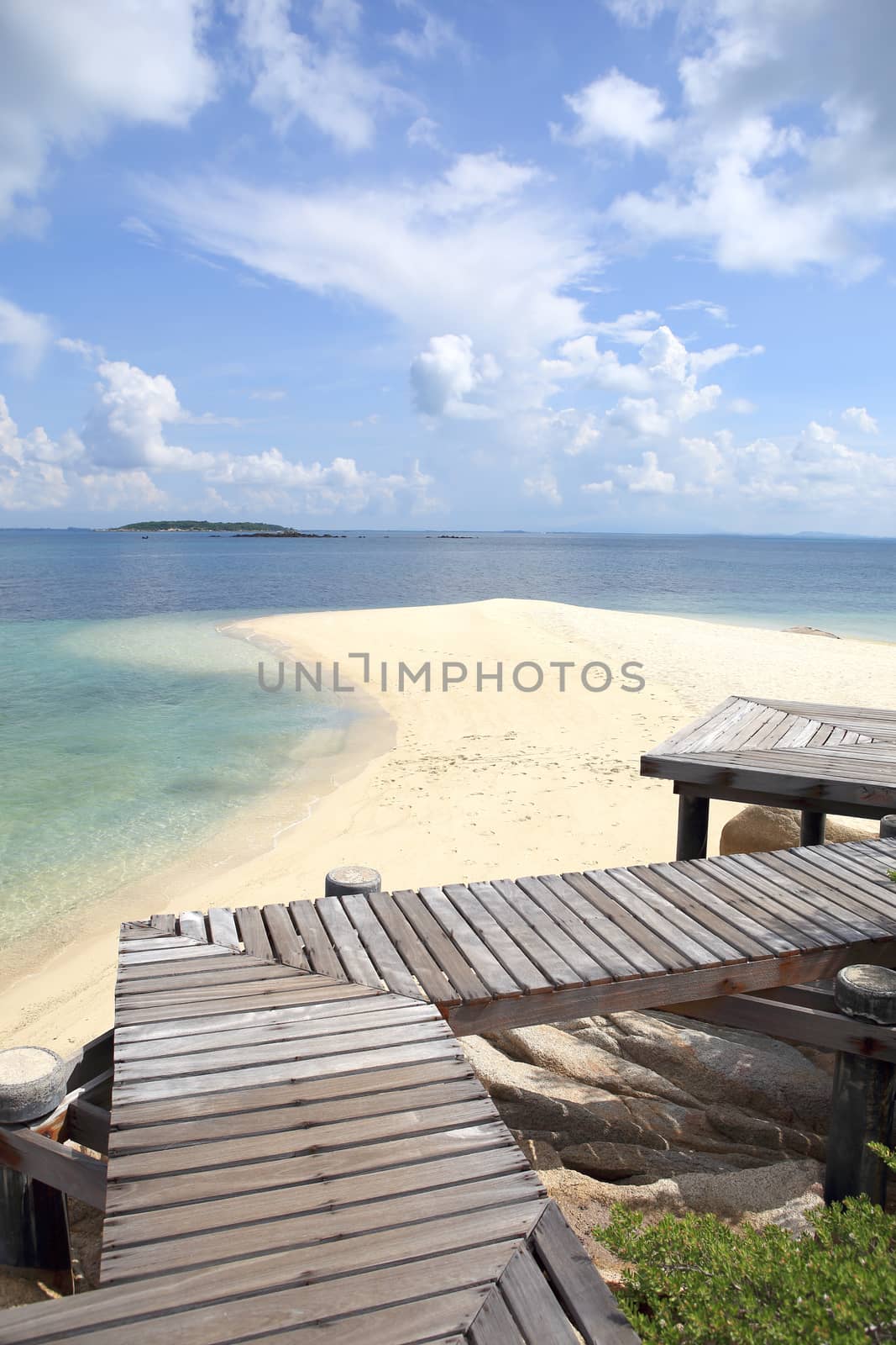 Wooden jetty on tropical beach on island by rufous