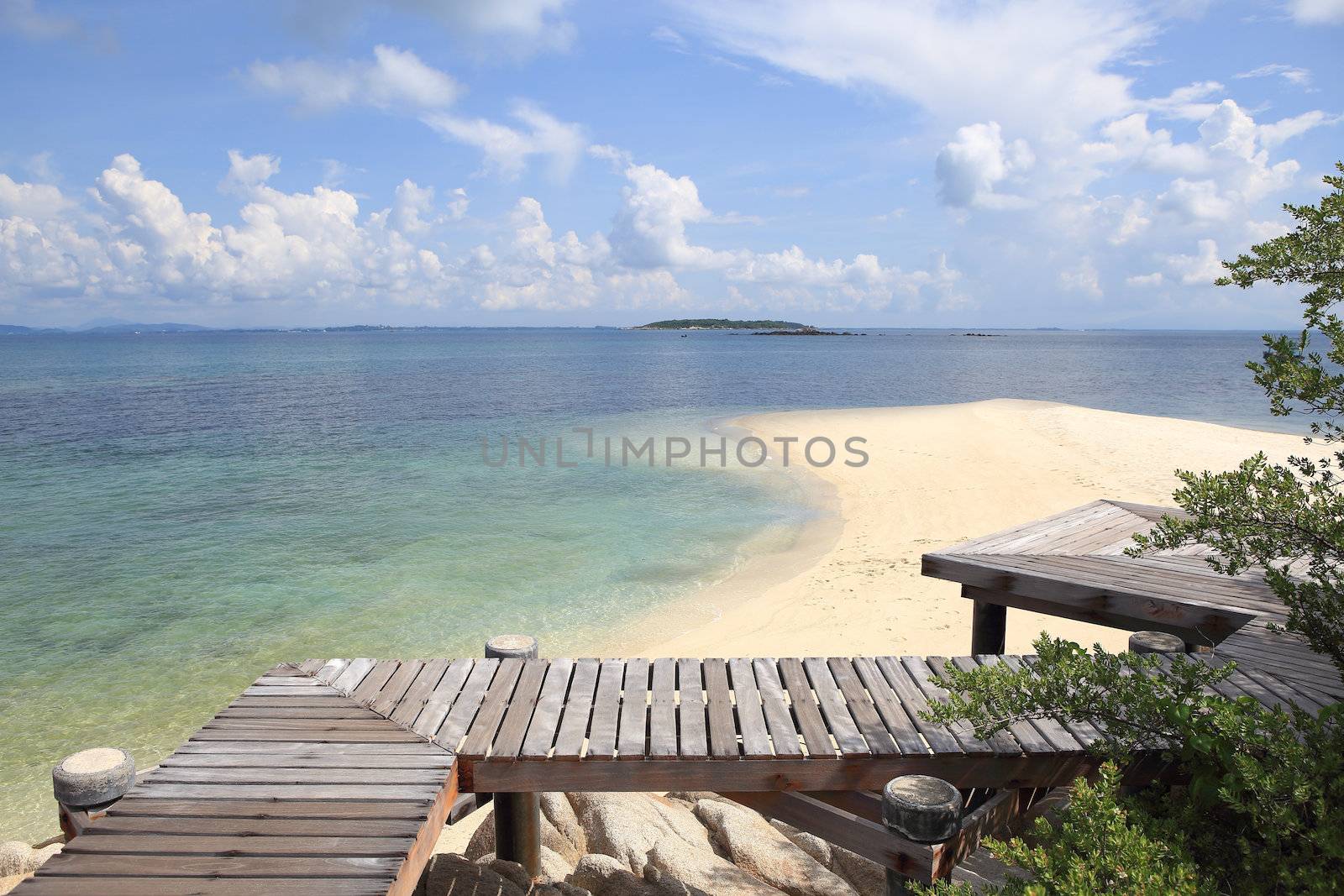 Wooden jetty on tropical beach on island by rufous