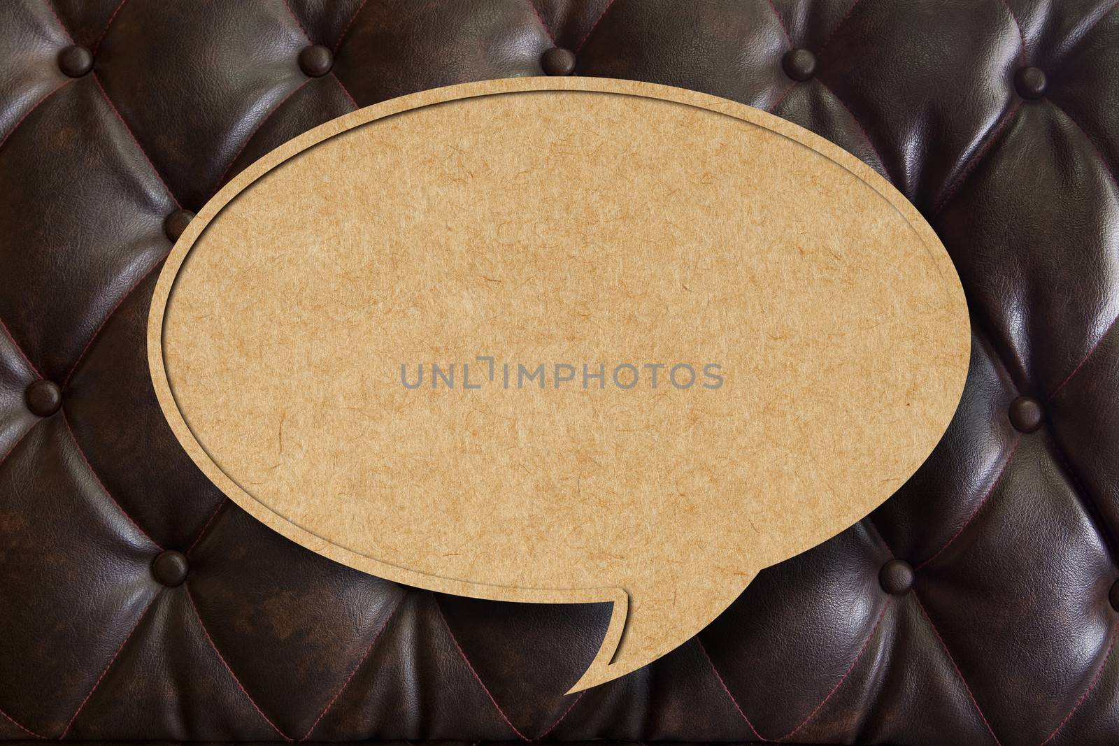 Recycle paper speech bubble on leather upholstery background by tanatat