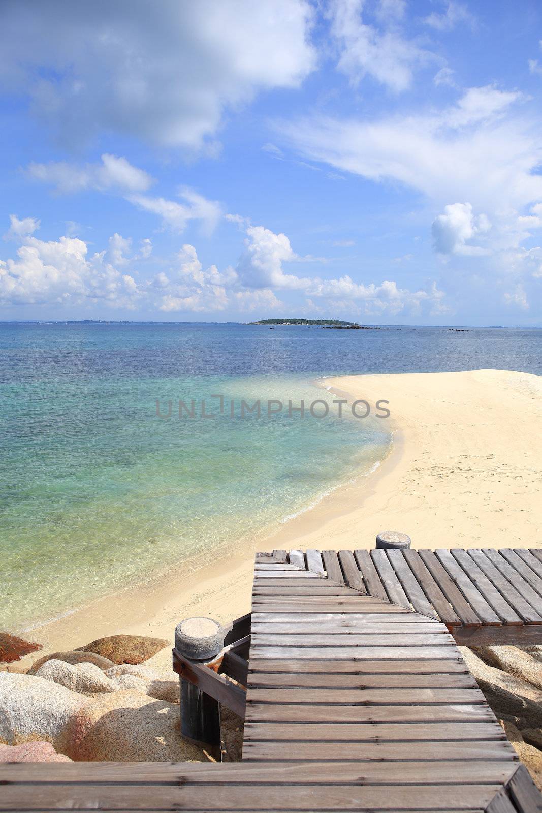 Wooden jetty on tropical beach on island