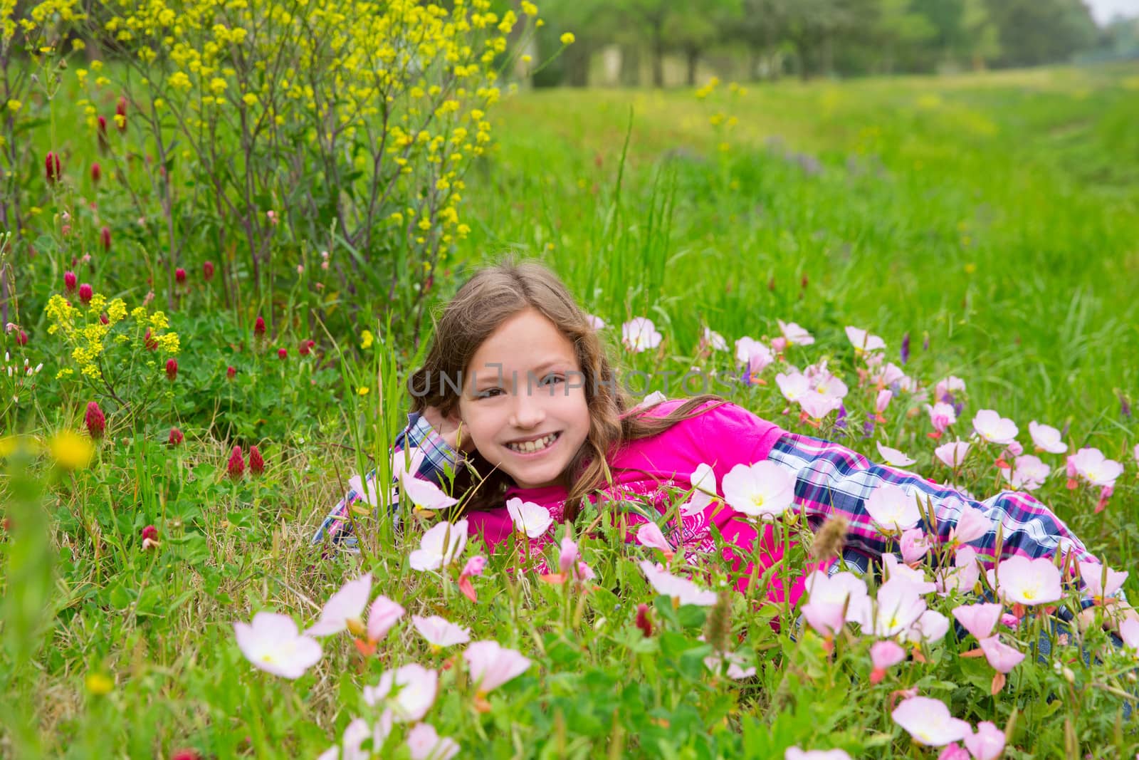 Happy relaxed kid girl on a spring flowers meadow by lunamarina