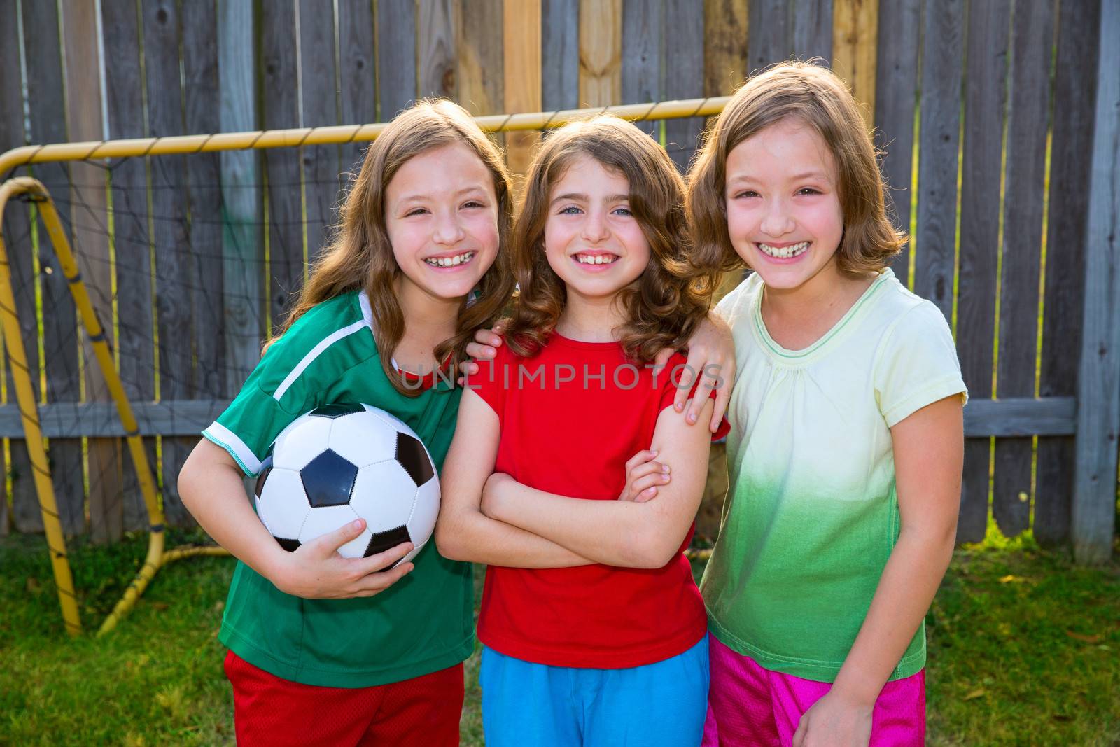 three sister girls friends soccer football winner players on the backyard