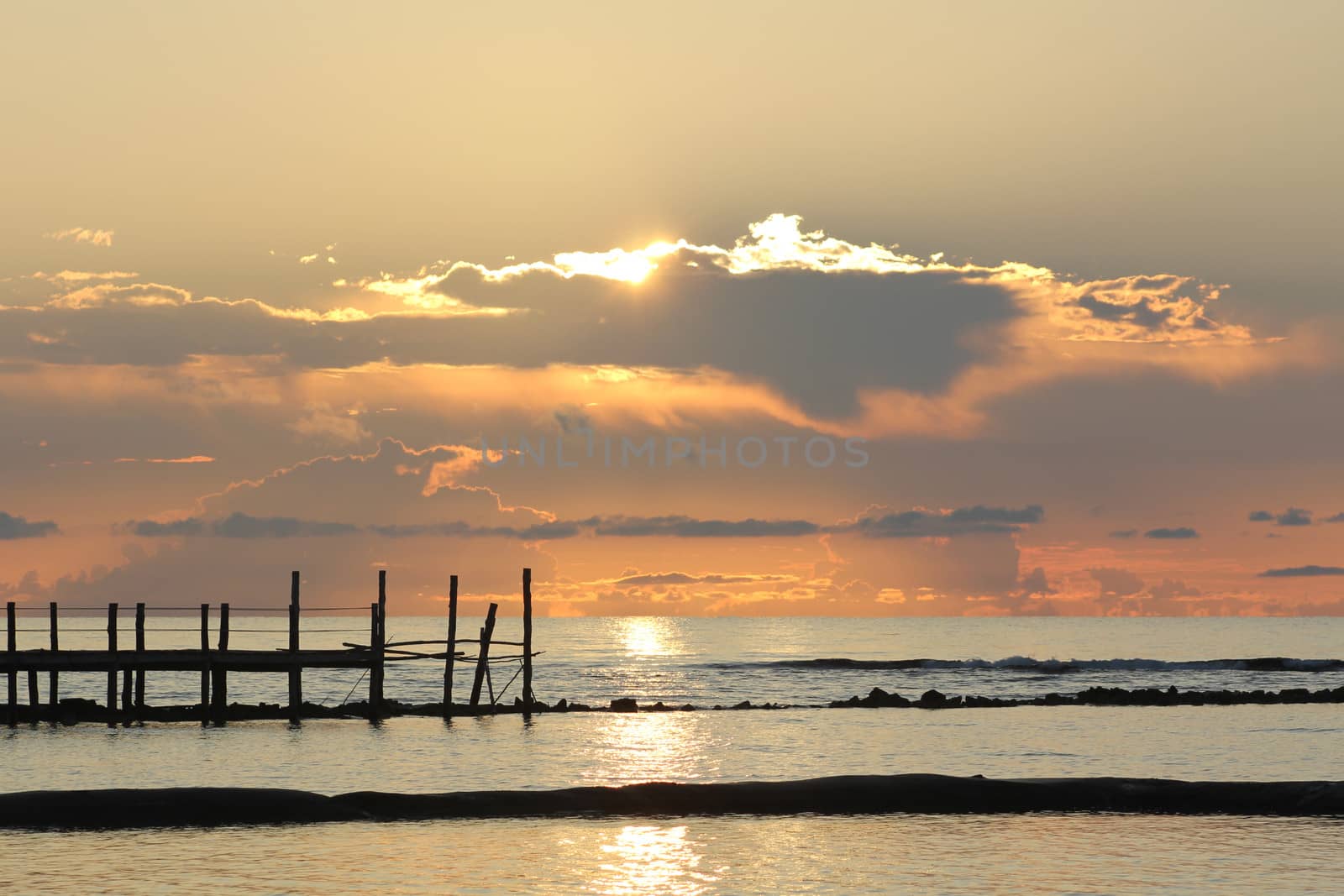 Fiery sunrise over a wooden pier at a tropical resort in the Mayan Riviera, Mexico