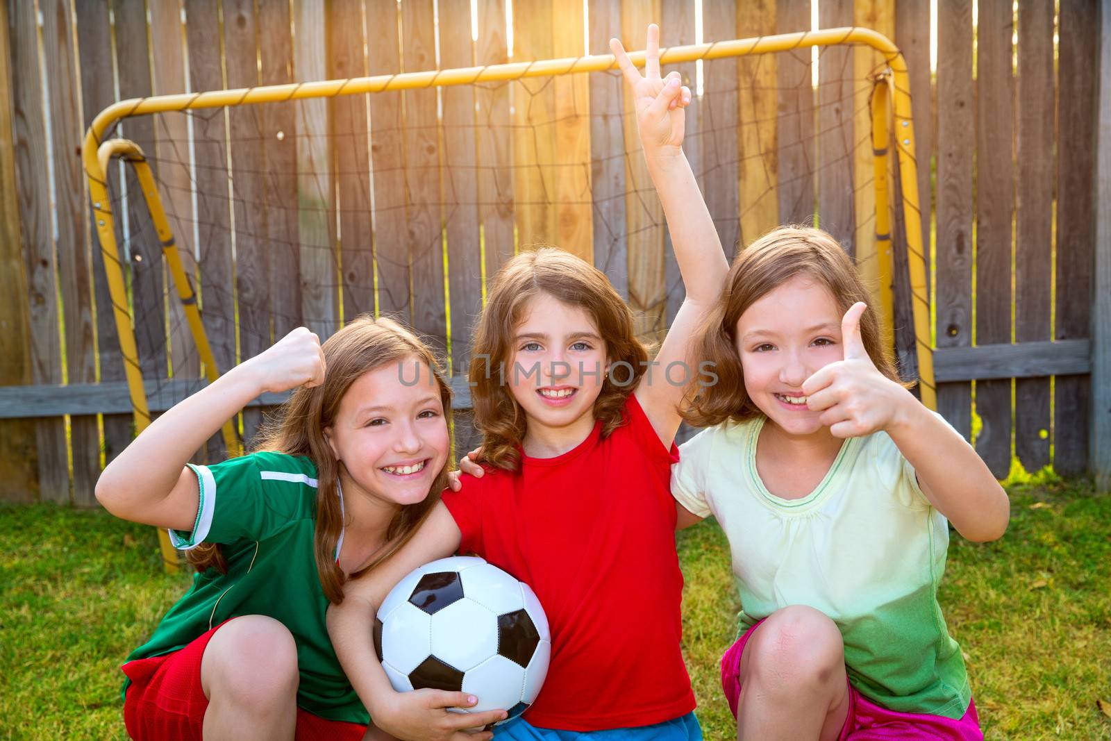 three sister girls friends soccer football winner players on the backyard