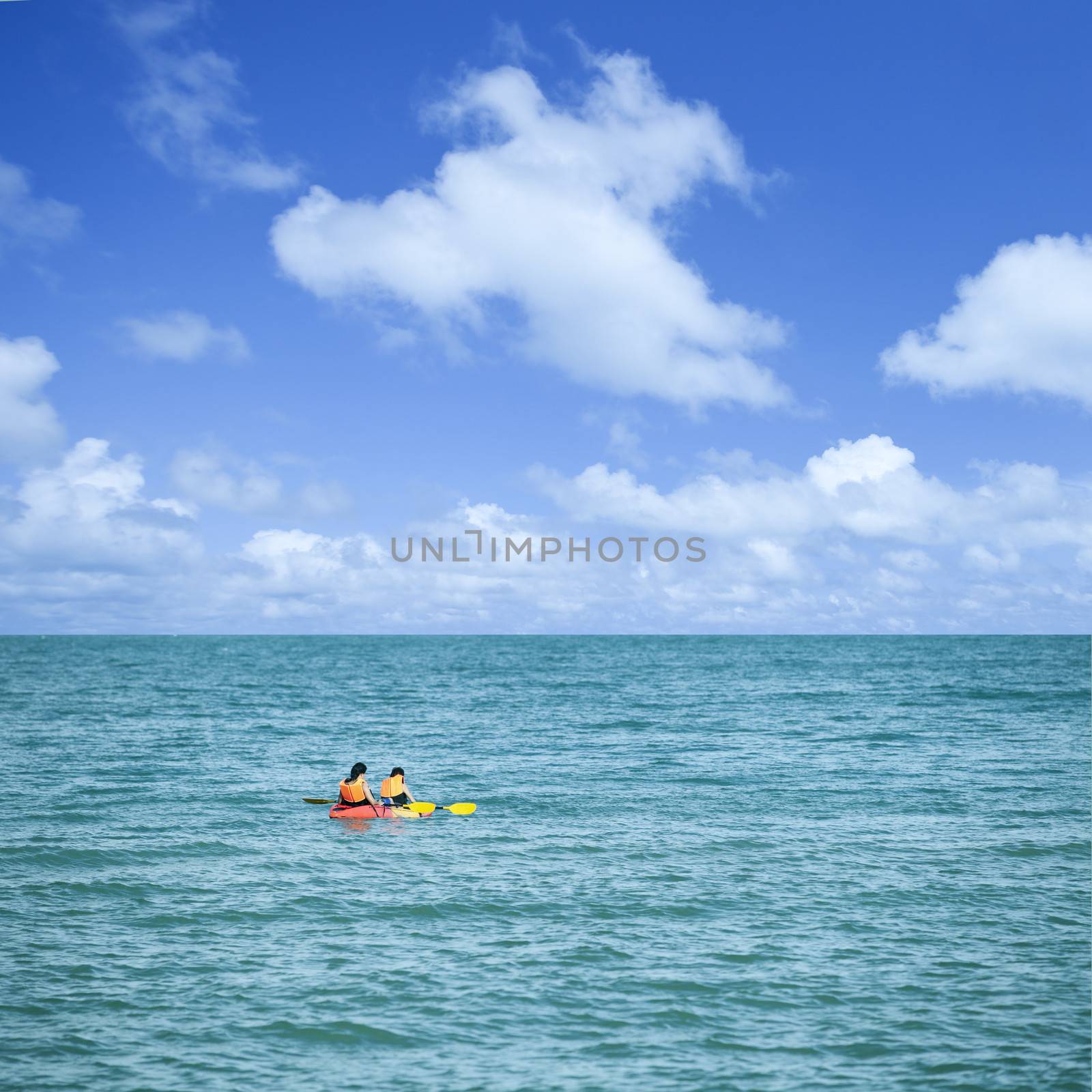 traveler kayaking in the sea with beautiful blue sky by tanatat